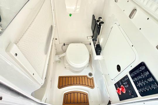 2026 Sea Hunt Ultra 255 SE boat interior with toilet and control panel.