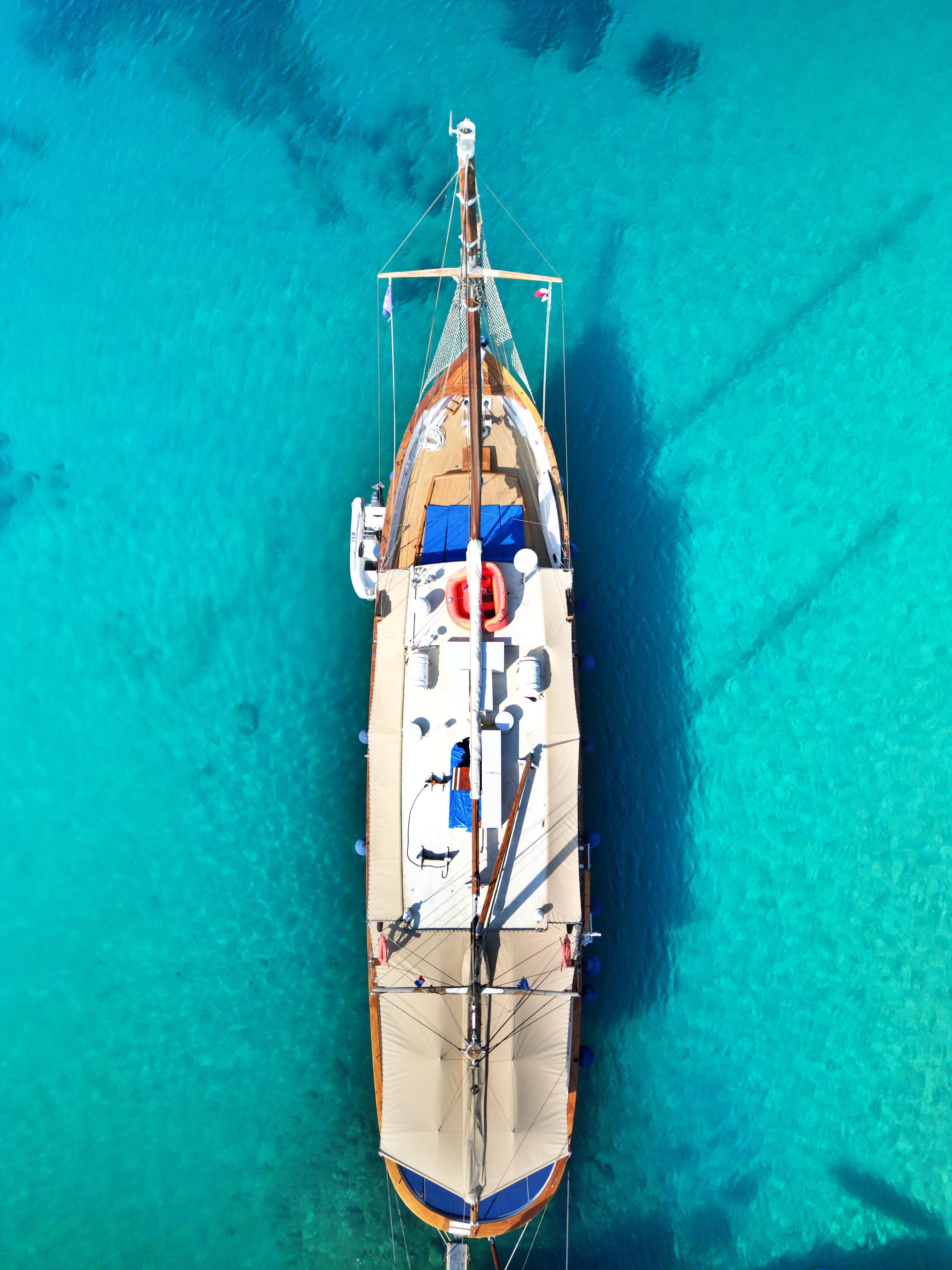 Aerial view of a 1969 Psarros Shipyard custom boat on clear turquoise water.
