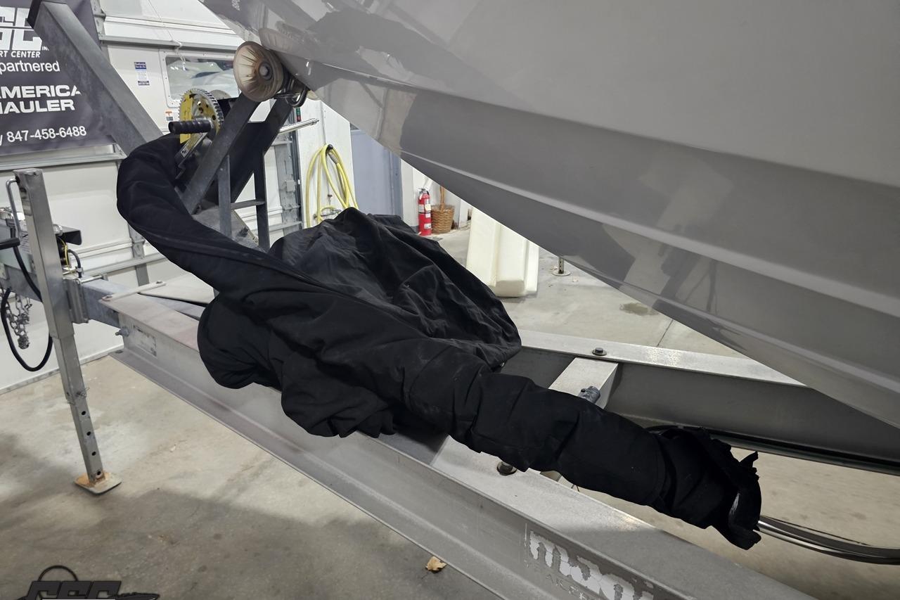 2008 Baja 335 Performance boat on trailer in garage, covered with protective black cover.