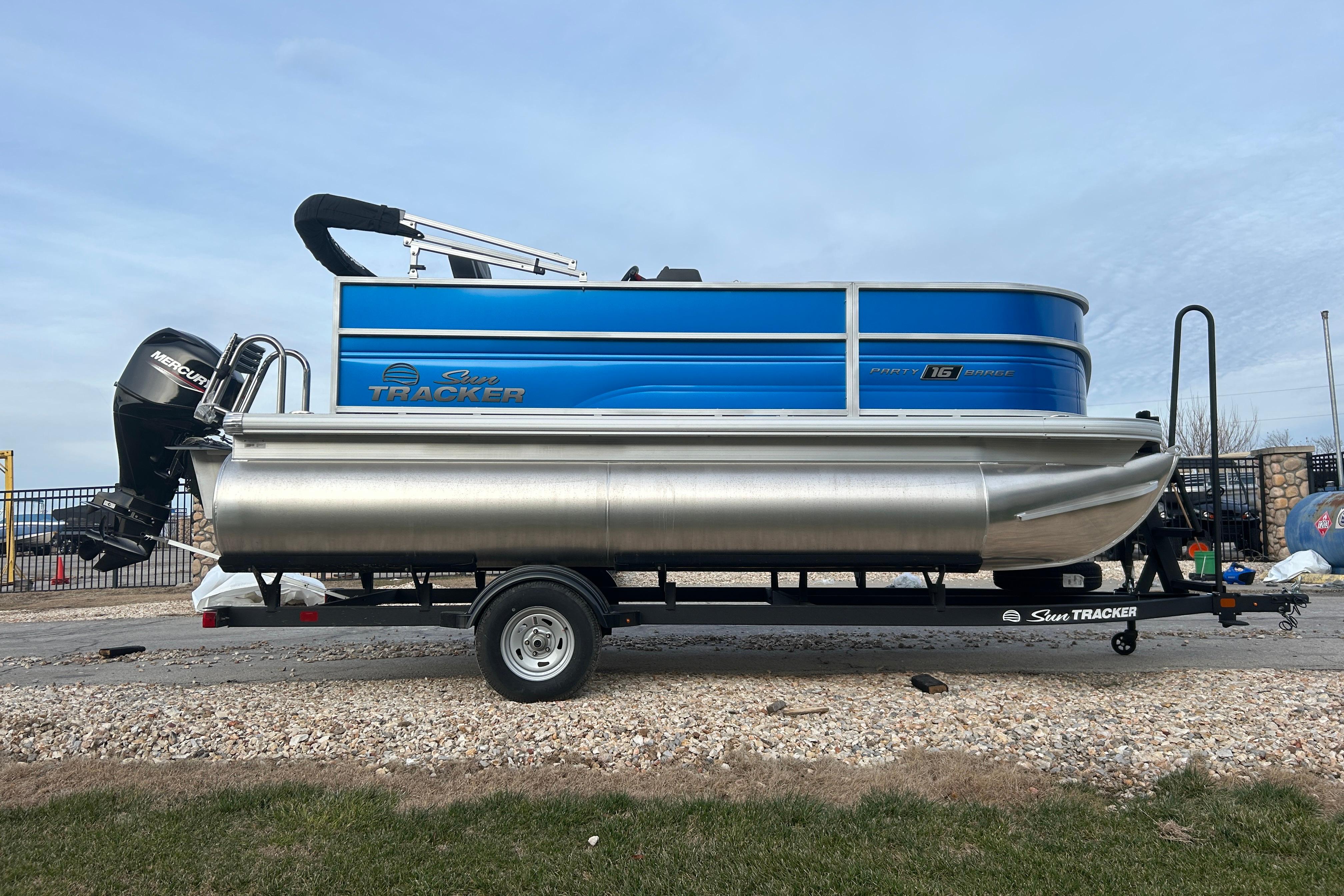 2026 Sun Tracker Party Barge 16 DLX pontoon boat on trailer, side view.