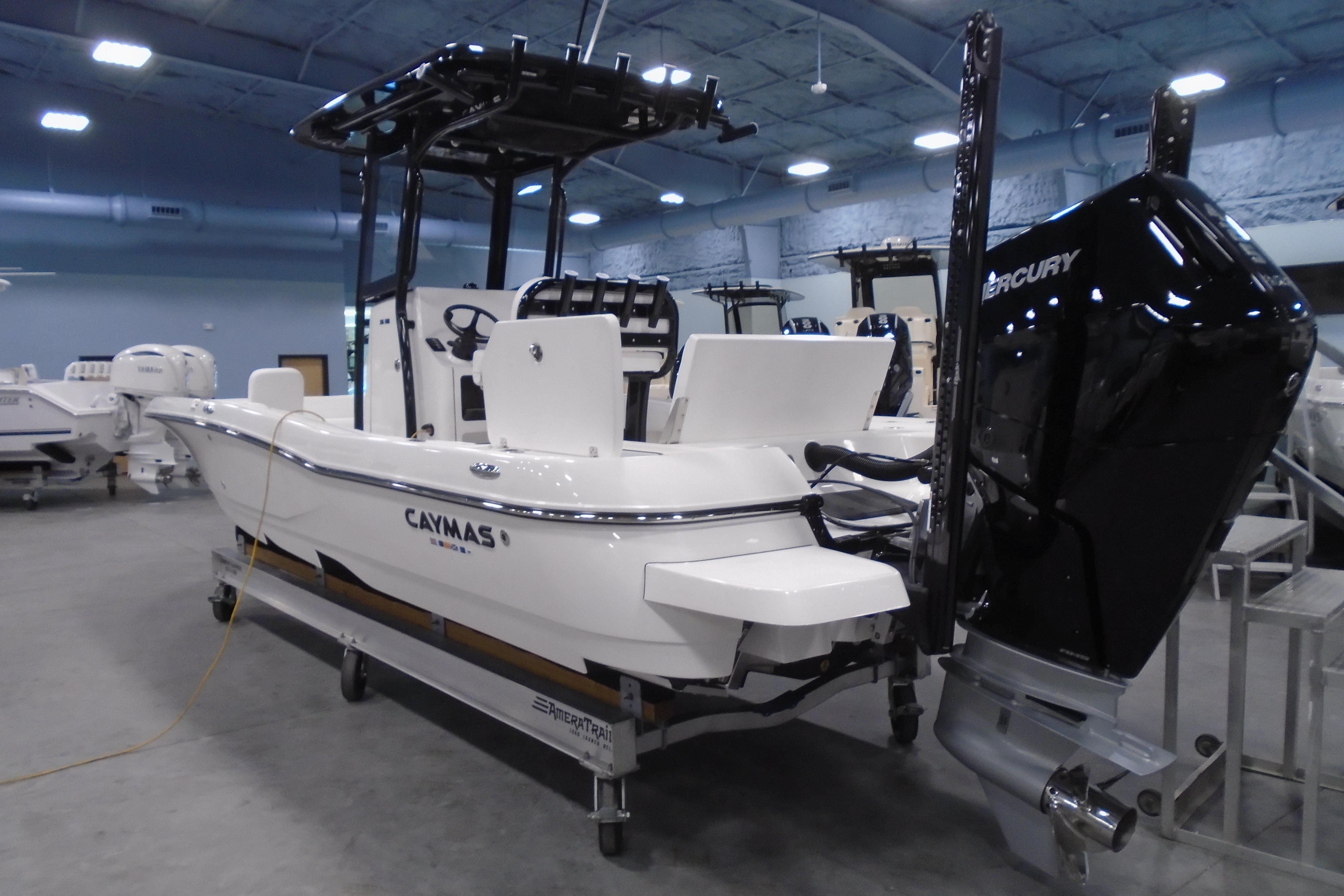 2026 Caymas 26 HB boat with Mercury engine in showroom setting.