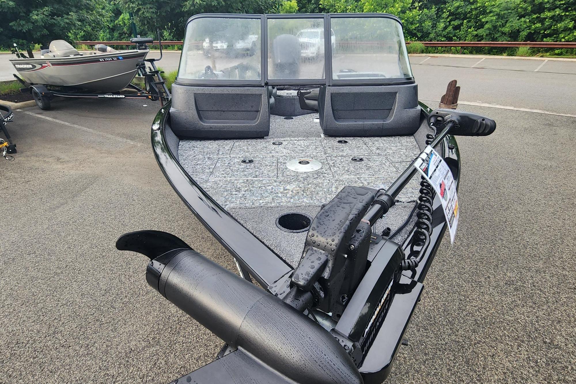 2026 Tracker Pro Guide V-16 WT boat with trolling motor, parked on asphalt.