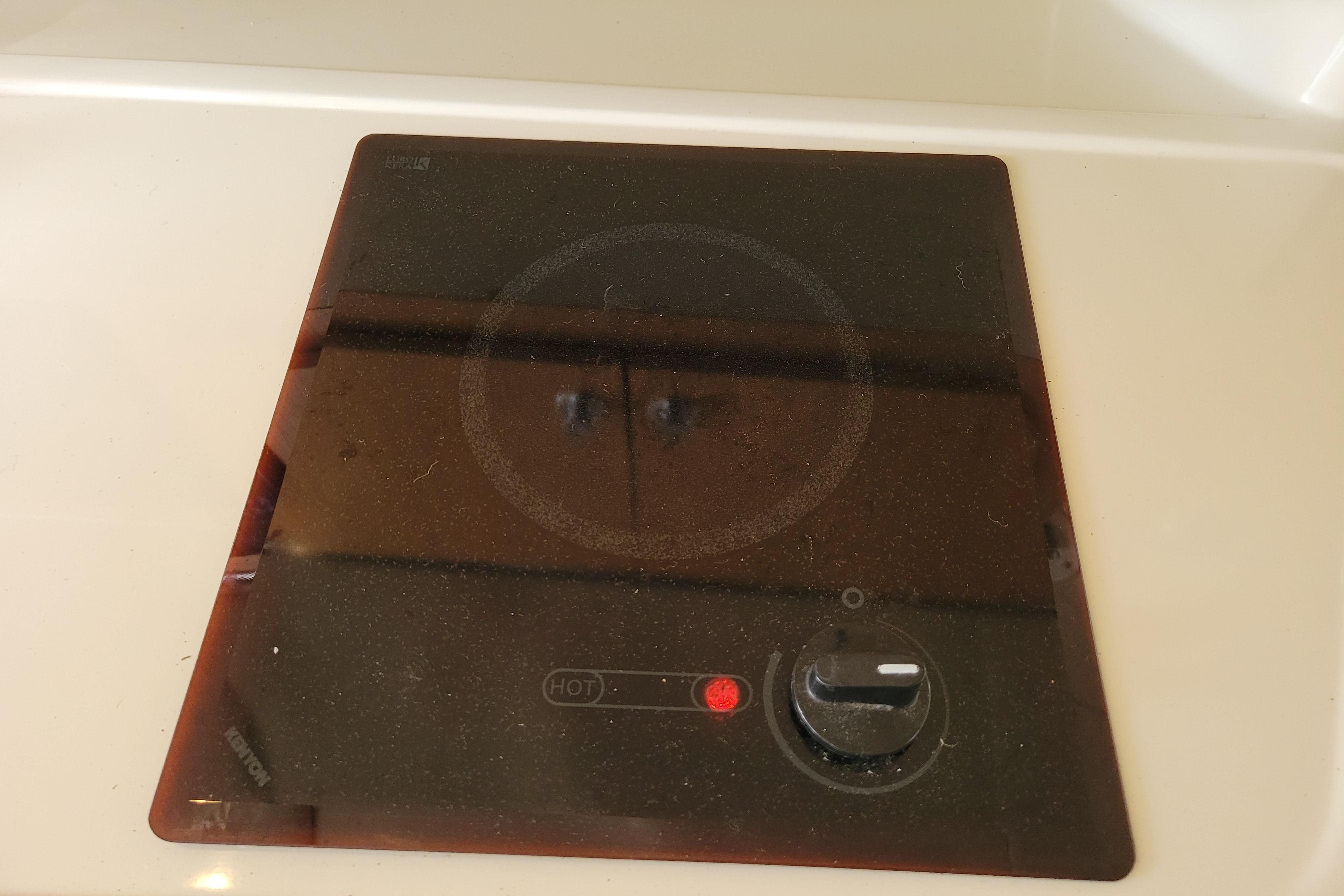 Black glass cooktop with control knob, installed on a 2007 Stingray 250 CS boat.