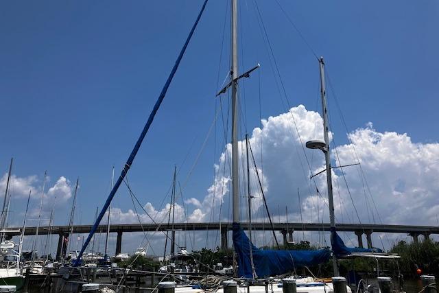 1979 Pearson 365 Ketch sailboat docked under a clear blue sky with clouds.