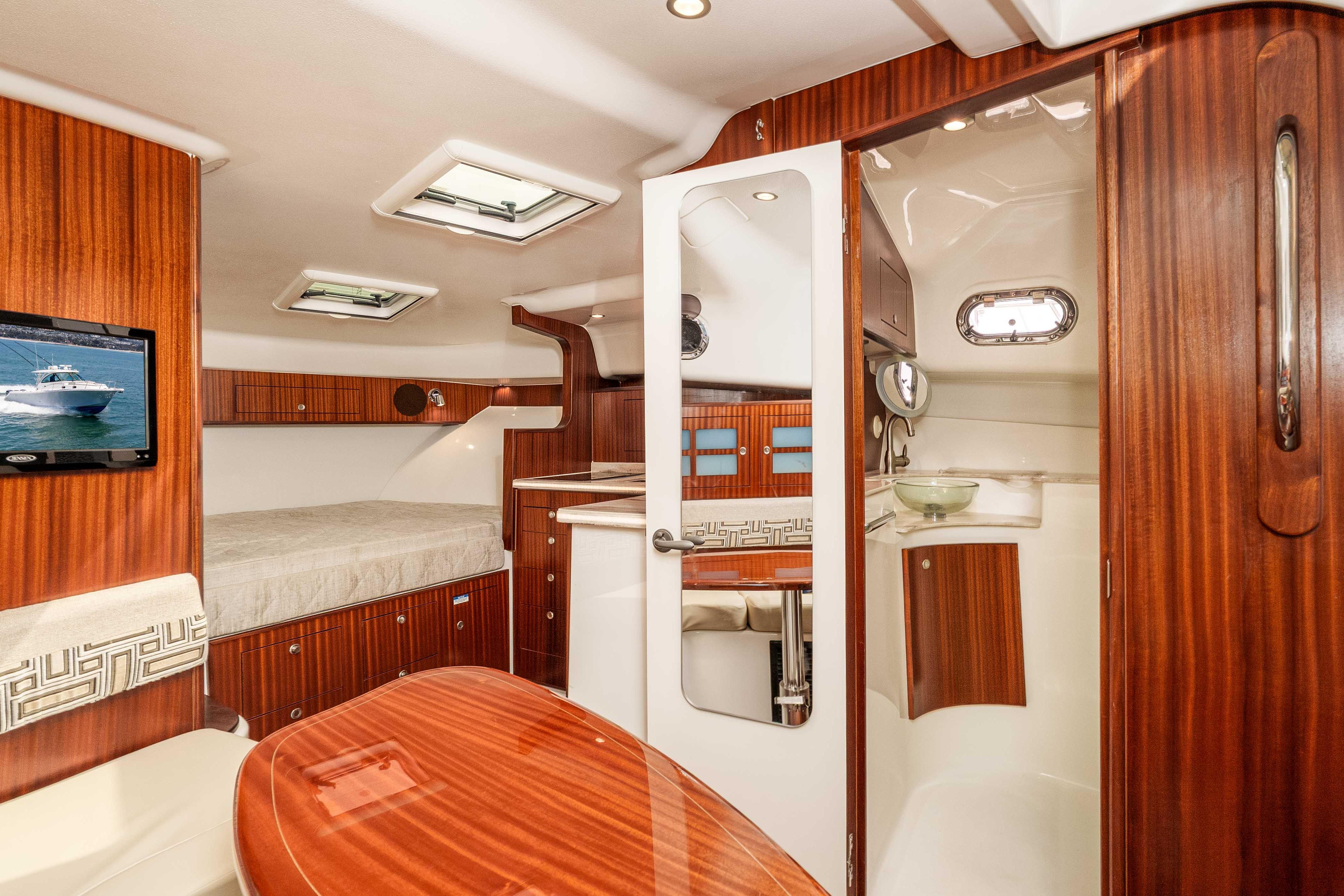 Luxurious interior of 2022 Pursuit OS 385 Offshore boat with wood finish and modern amenities.
