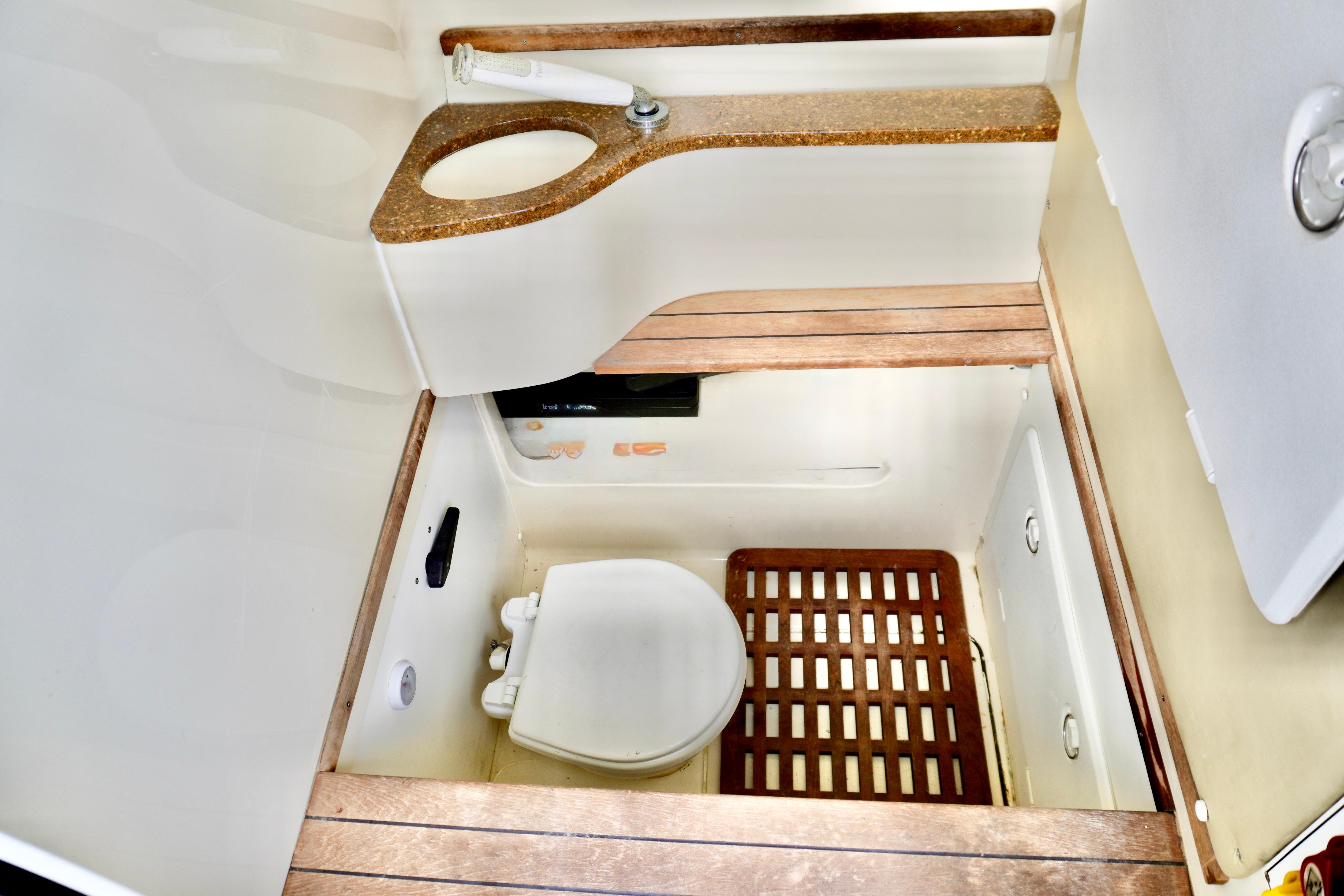 2013 Contender 35 LS boat bathroom with wooden flooring and compact design.