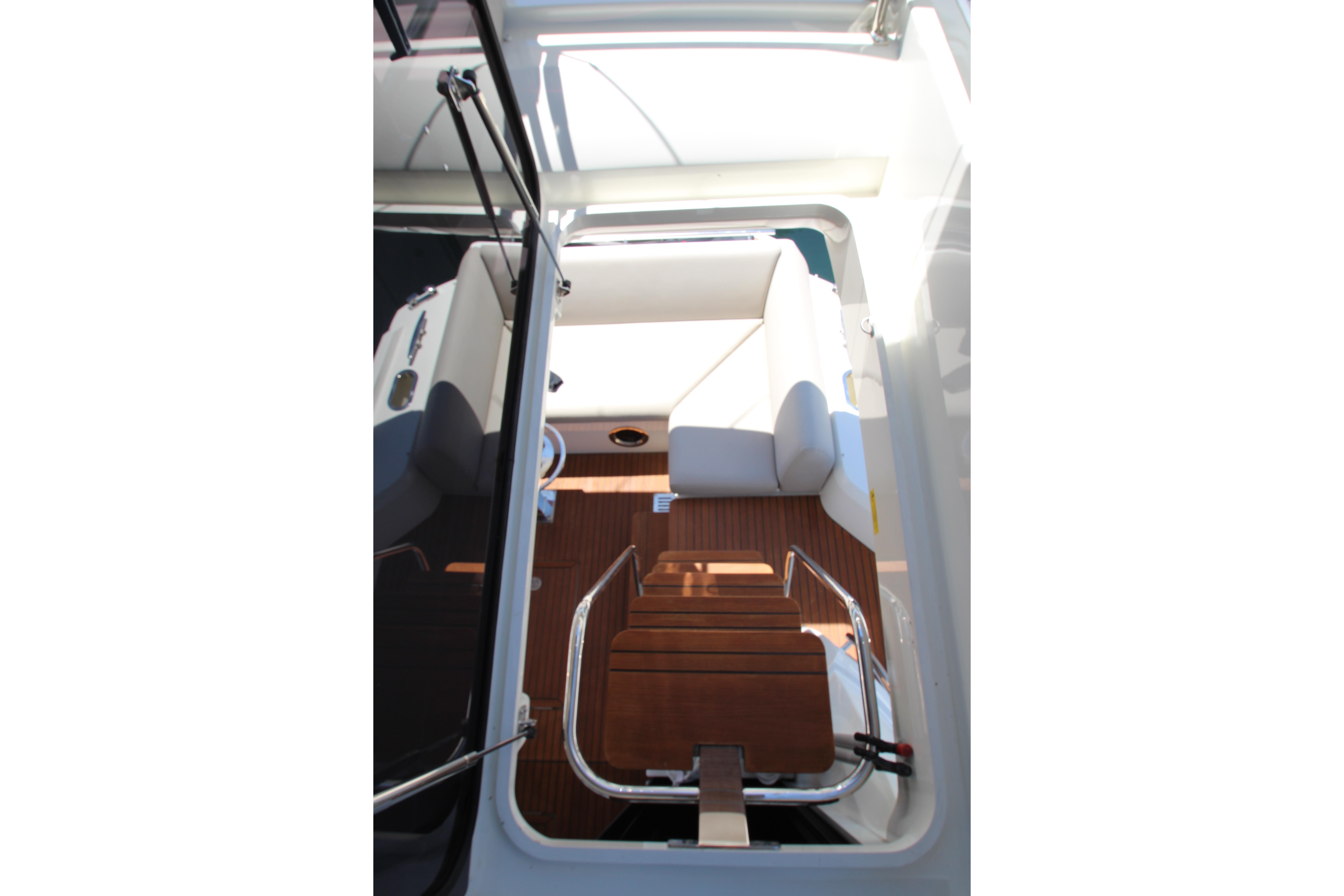Interior view of 2022 Prestige 520 yacht, featuring wooden steps and white seating.