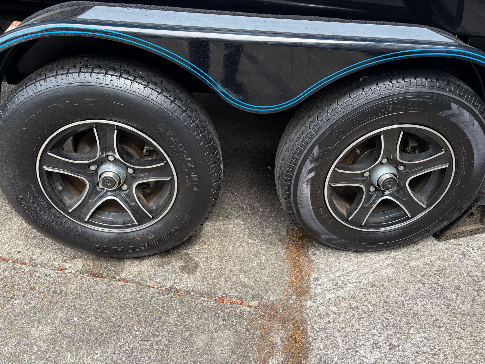 Close-up of two trailer tires on concrete.