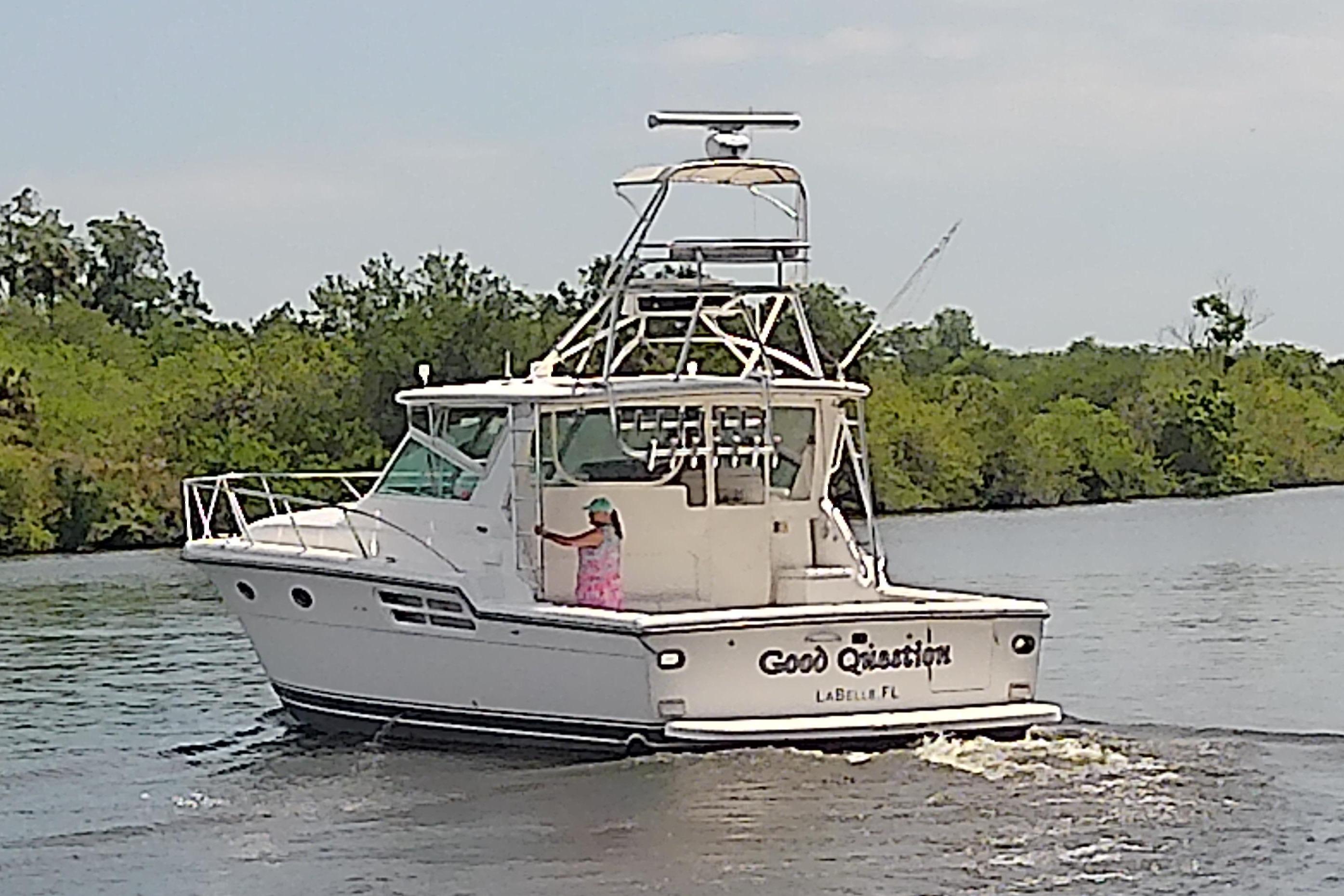 2000 Tiara Yachts 4100 Open cruising on a scenic river near lush greenery.