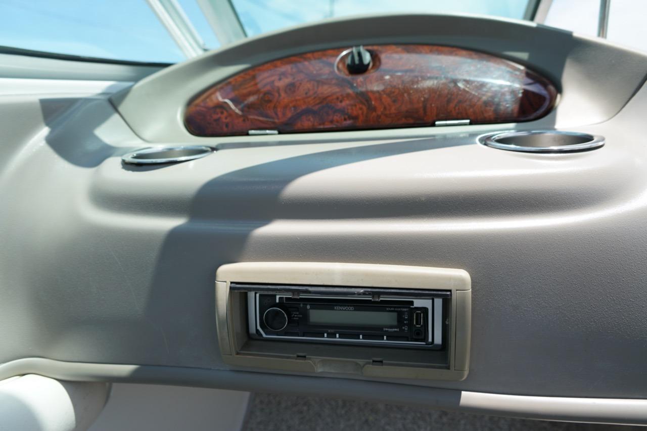 Dashboard of a 2004 Crownline 216 LS boat with stereo system and cup holders.