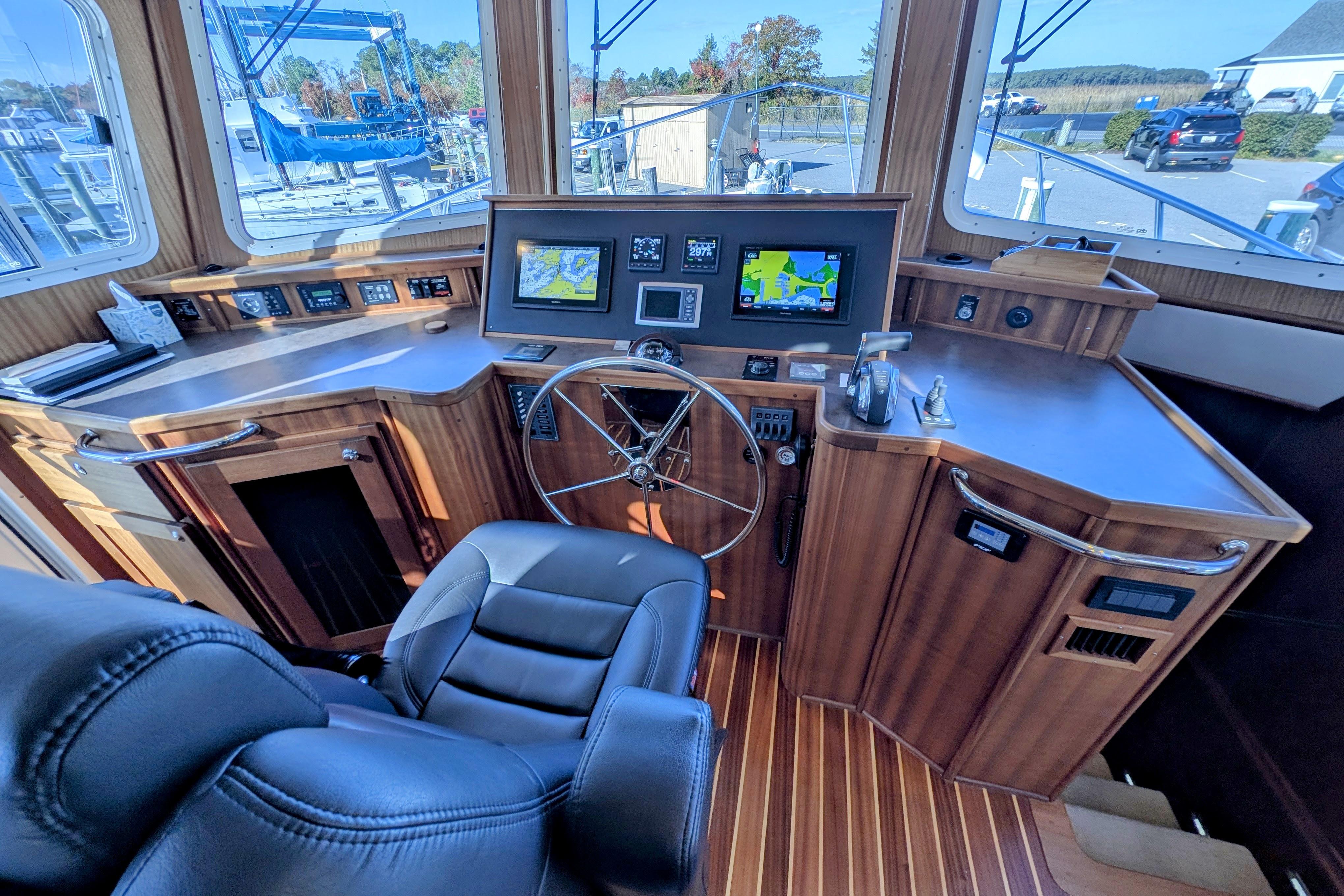 Pilothouse of 2015 American Tug 435 with navigation screens and wooden interior.