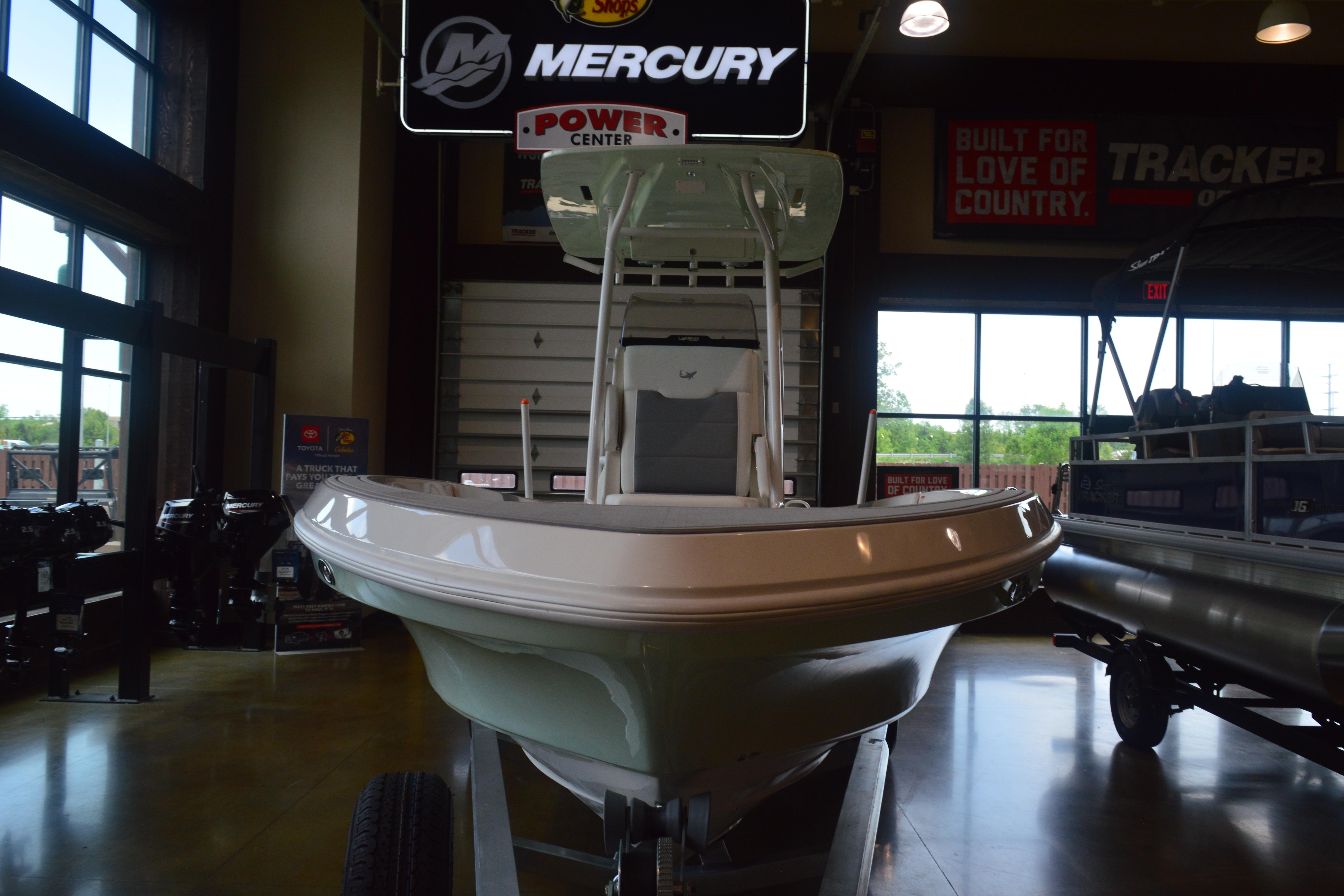 2026 Mako 24 APEX boat displayed indoors at a Mercury Power Center.