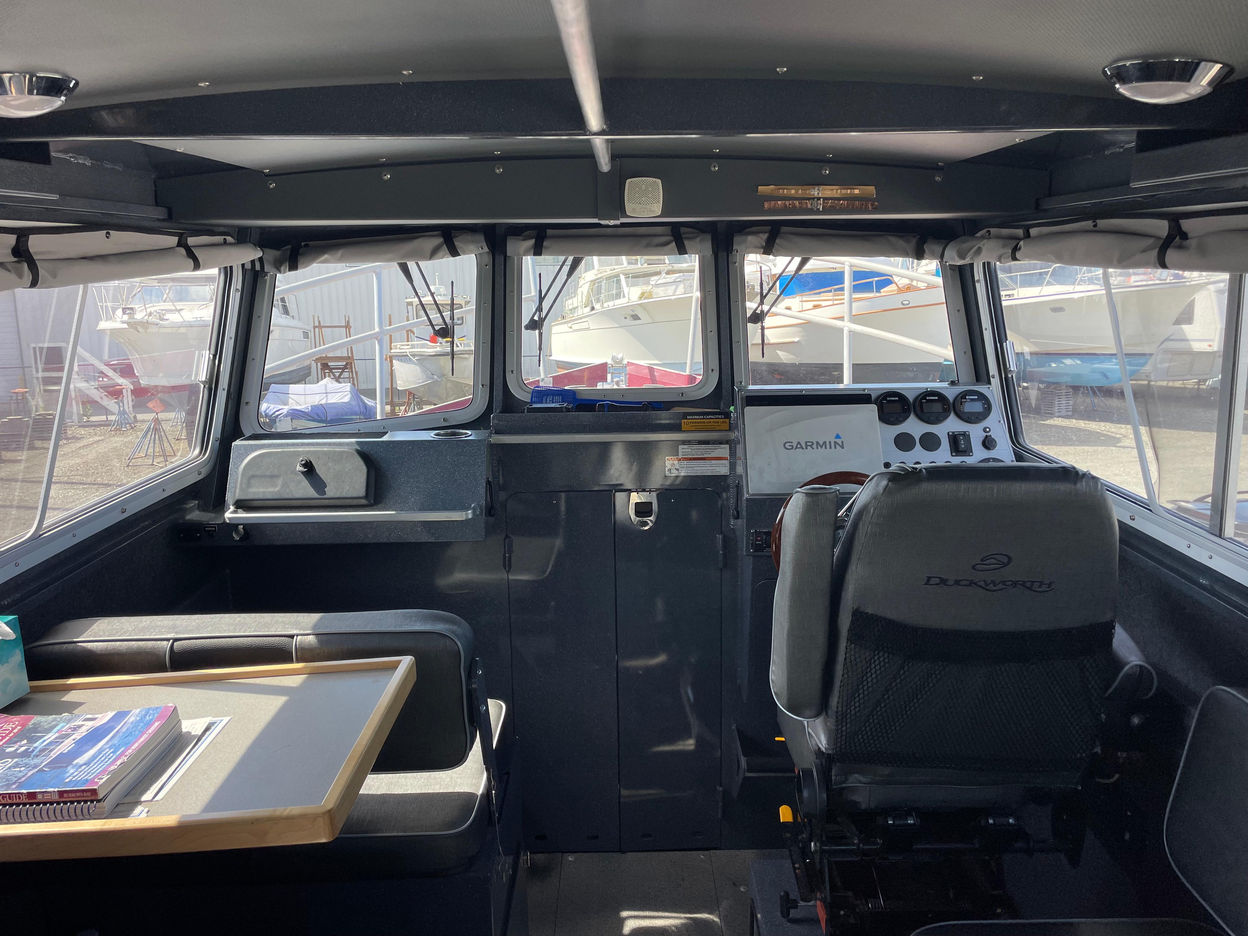 Interior of a 2018 Duckworth 28 Offshore boat with seating and control panel.