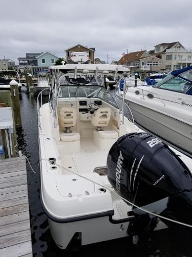 2011 Boston Whaler 235 Conquest boat docked at marina with Mercury engine.