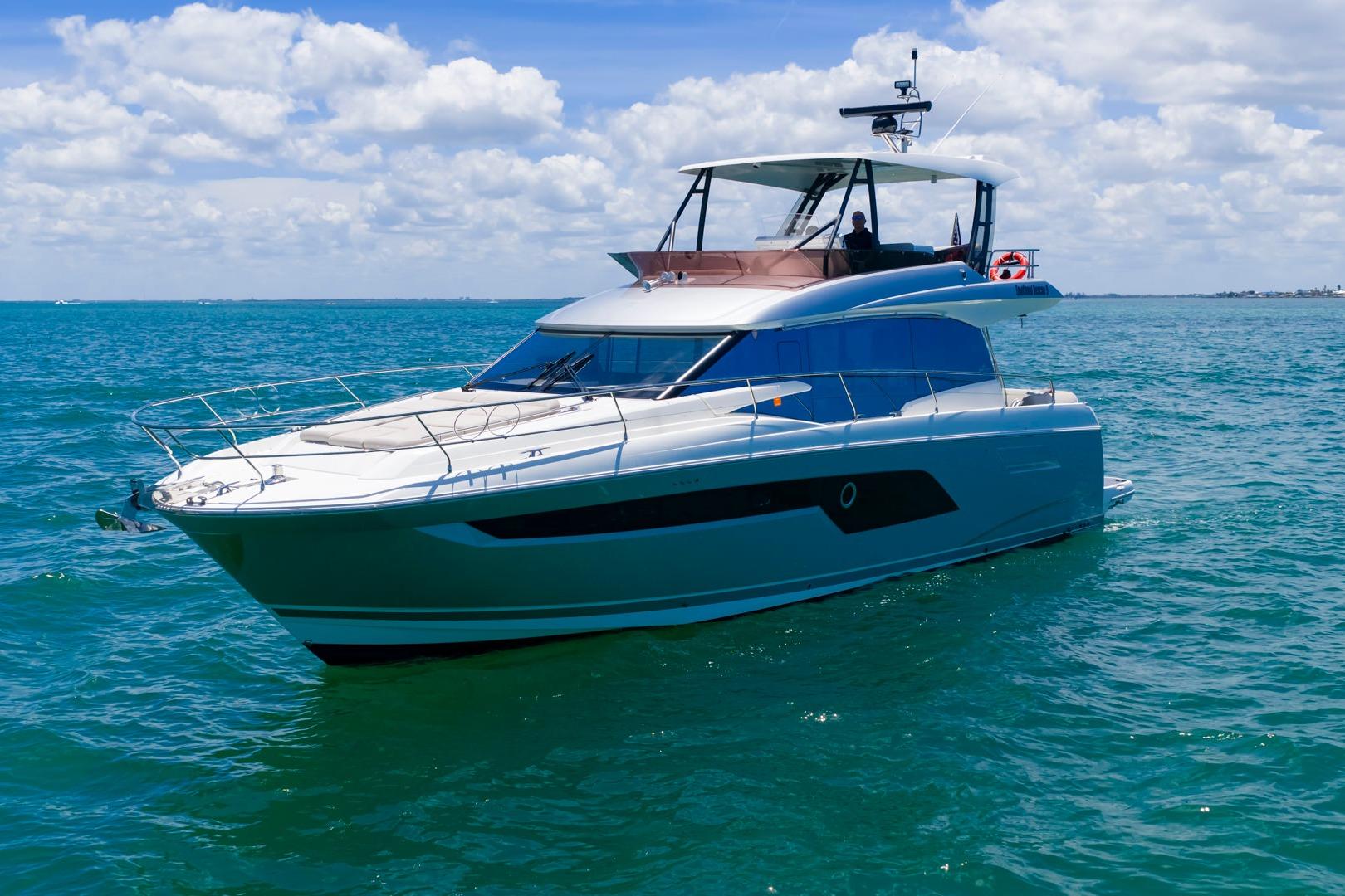 Luxury 2022 Prestige 520 yacht cruising on clear blue ocean waters.