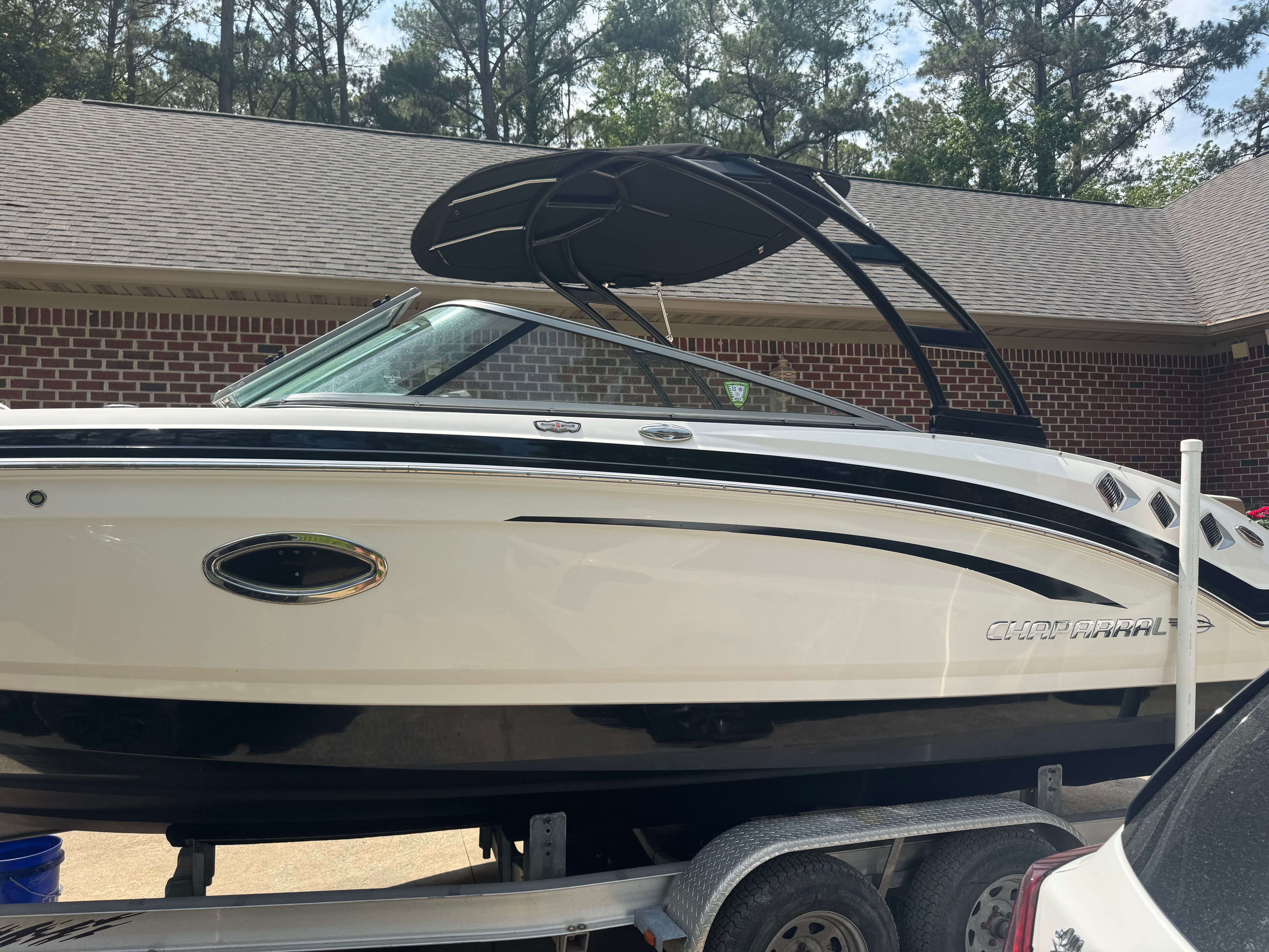 2016 Chaparral 246 SSi boat on trailer in front of brick building.