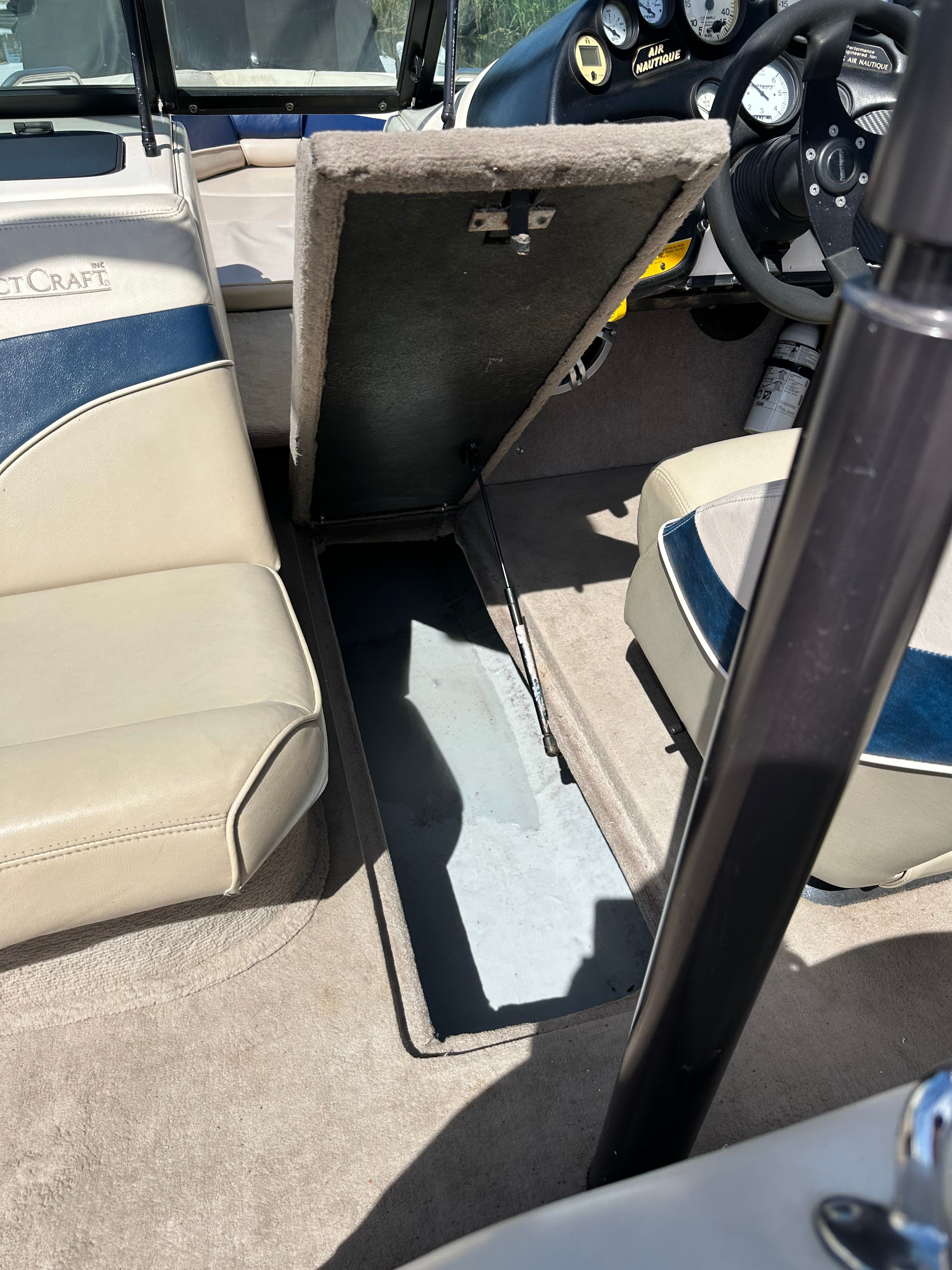 Interior of a 1998 Correct Craft Air Nautique boat with open storage compartment.