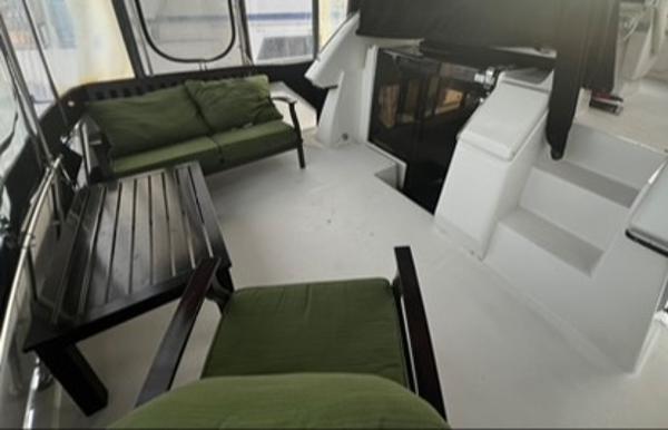 1991 Carver 33 Aft Cabin Motor Yacht interior with green seating and wooden table.