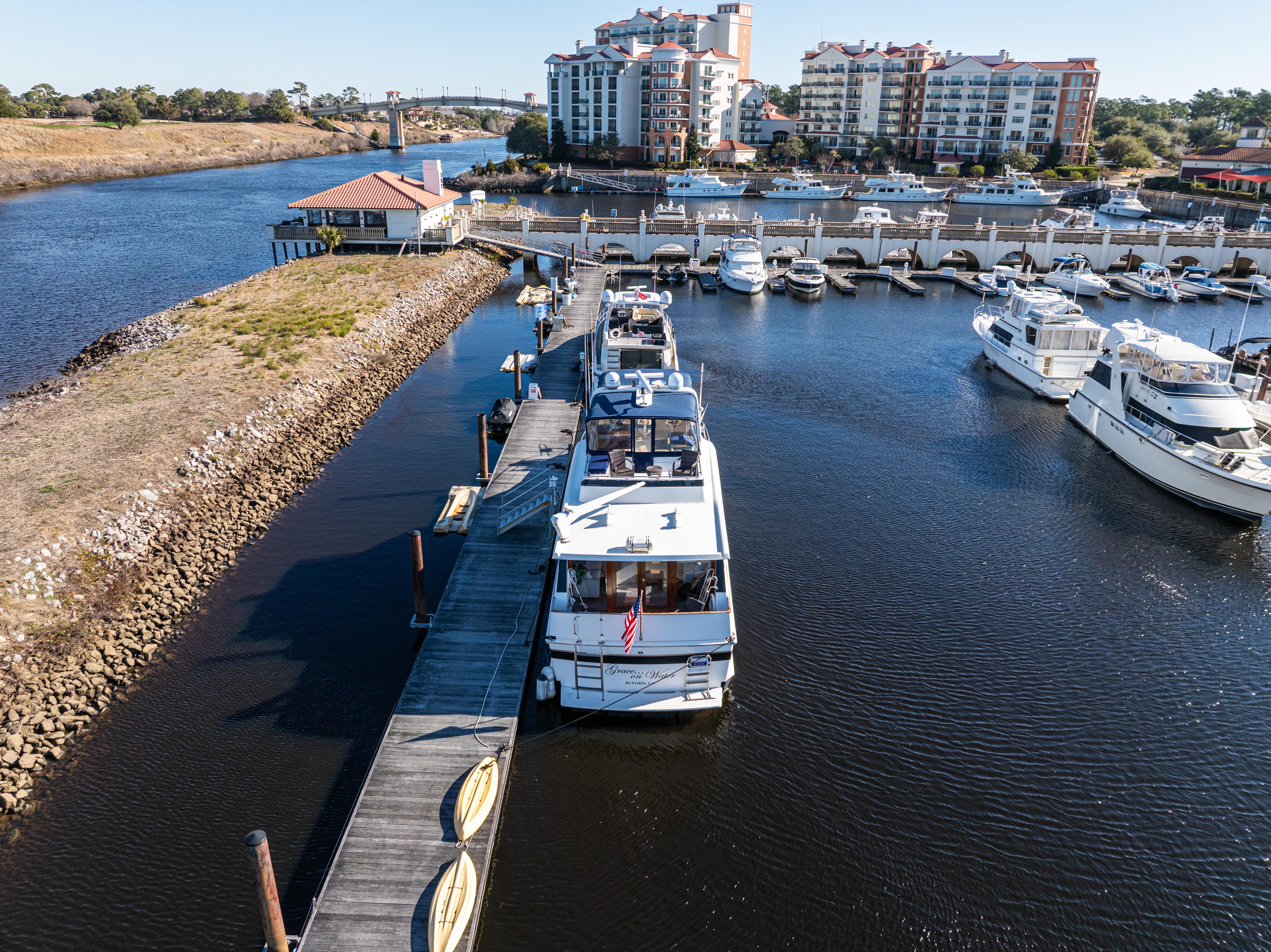 1989 Viking 63 Motor Yacht docked at marina with waterfront buildings in background.