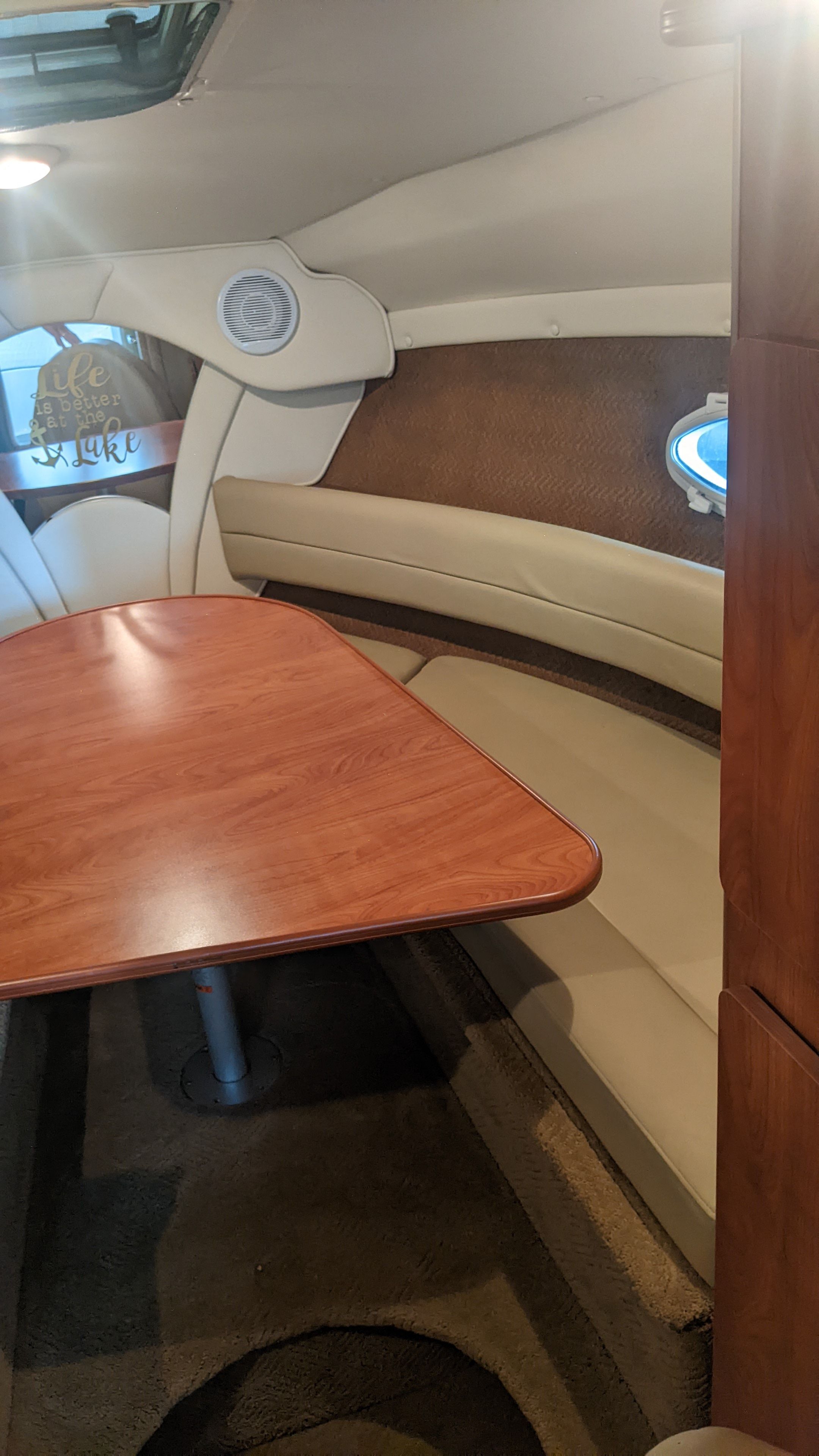 Interior of a 2006 Rinker 250 EC with wooden table and seating.