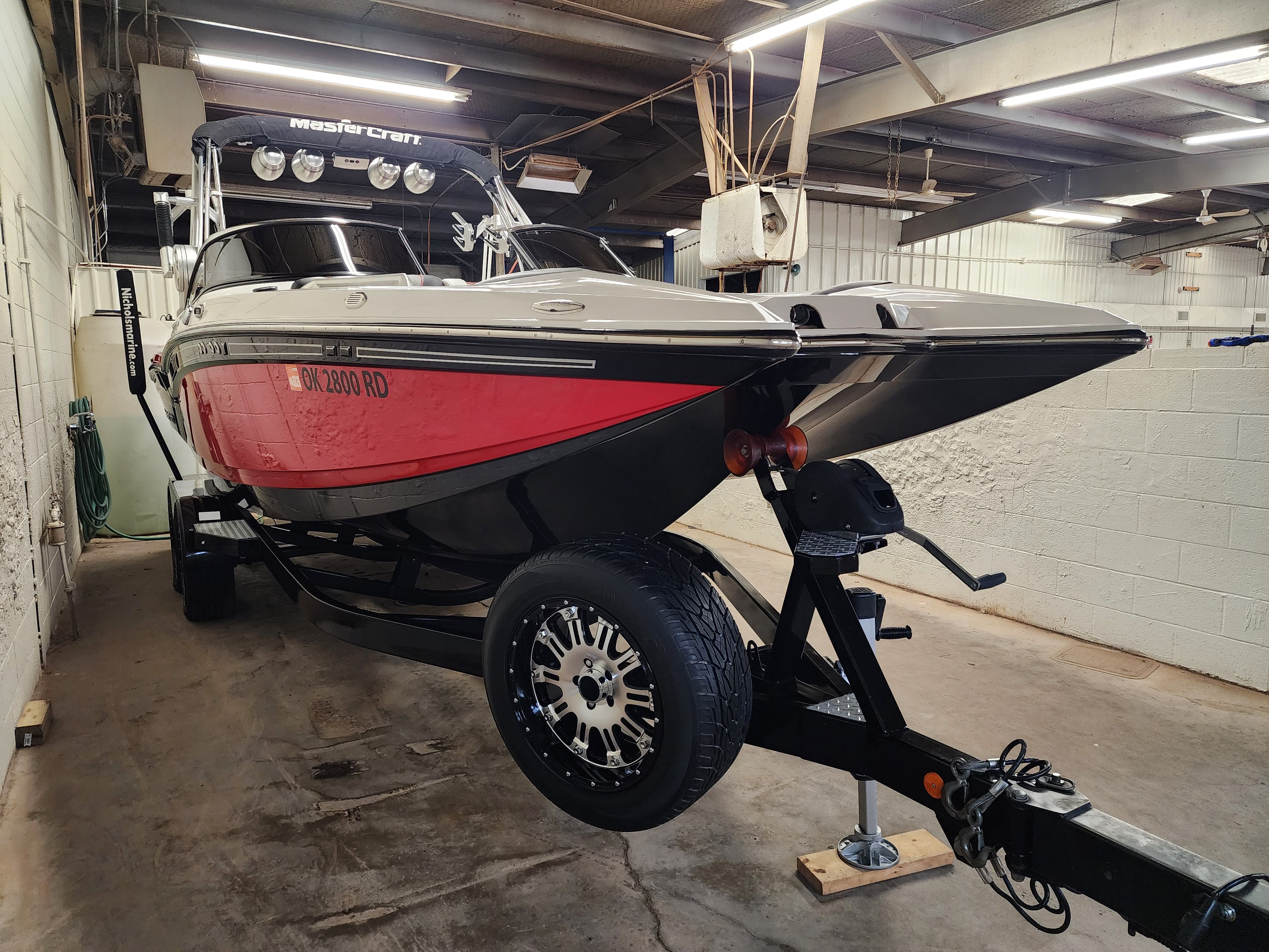 2013 MasterCraft XStar boat in a garage on a trailer.