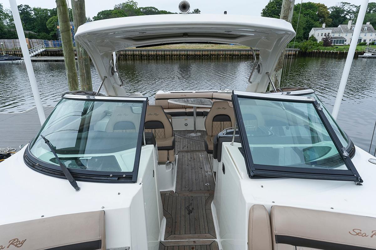 2018 Sea Ray SLX 350 boat interior with seating, docked by a calm waterfront.