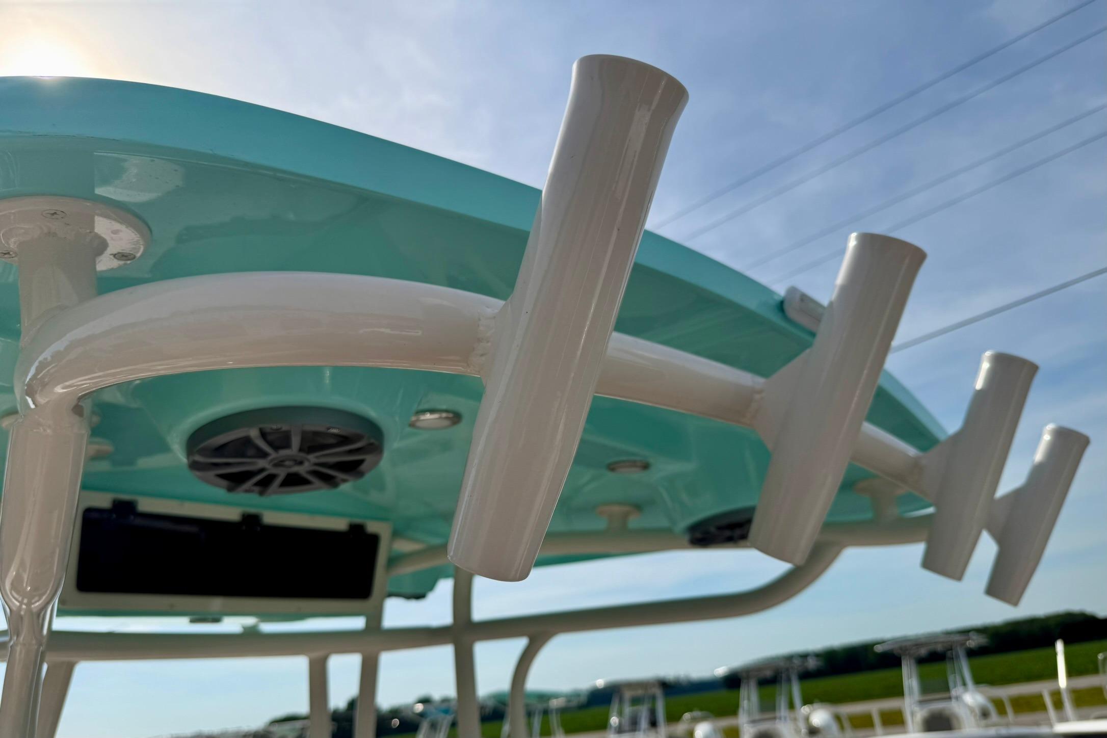 2026 Carolina Skiff 24 Ultra Elite boat with rod holders and speakers under a blue sky.