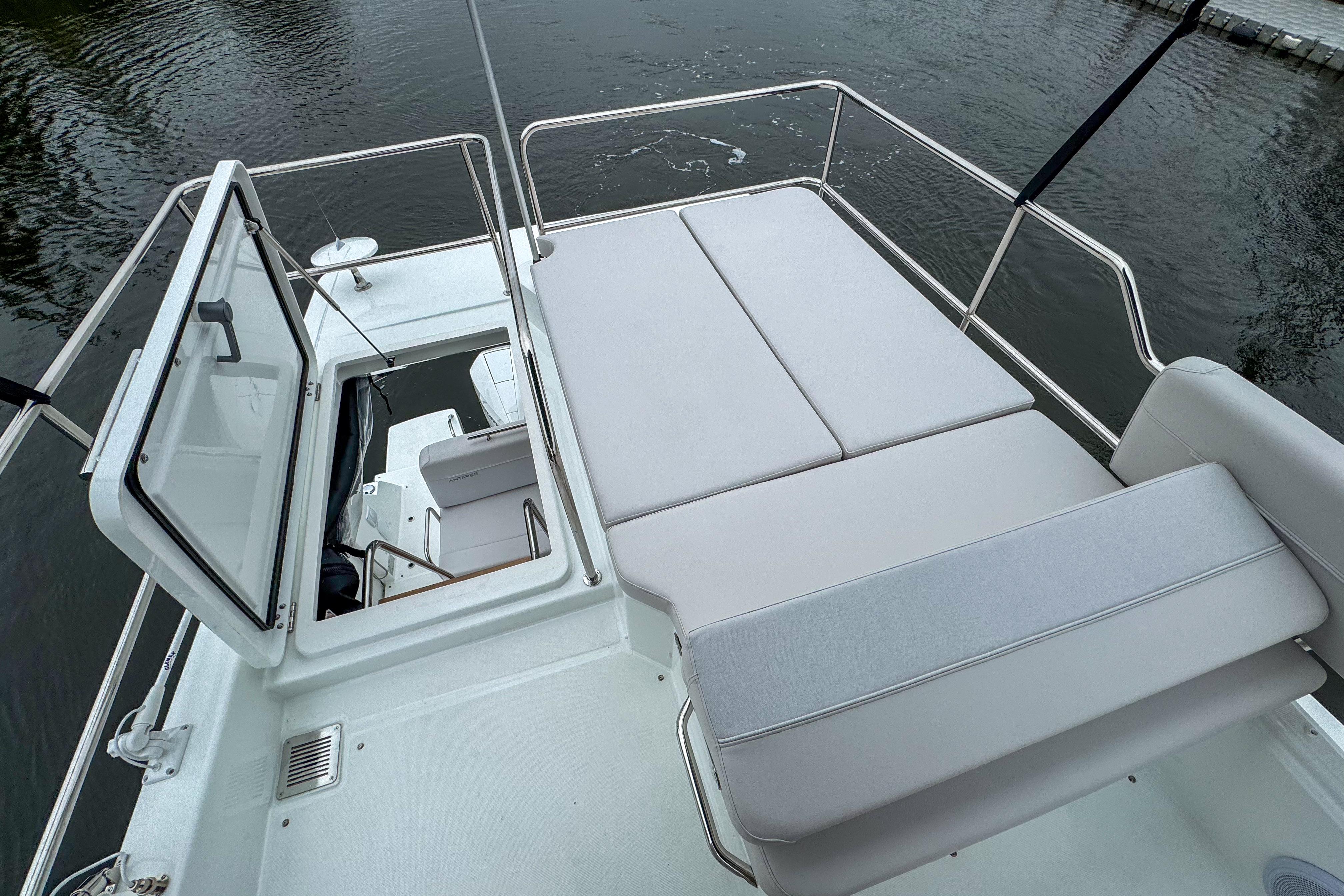 2026 Beneteau Antares 11 boat deck with cushioned seating and open hatch.