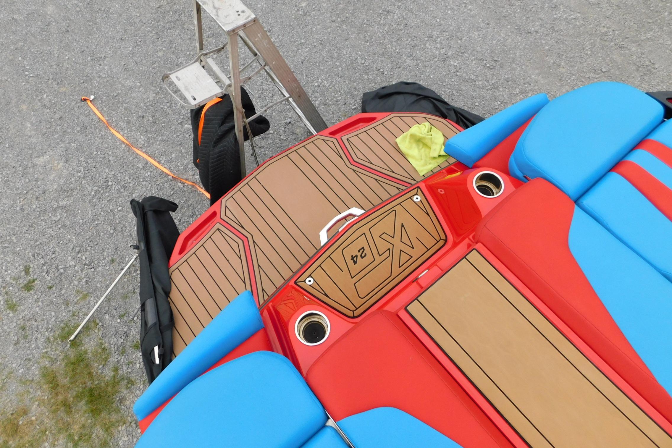 2022 MasterCraft NXT24 boat with vibrant red and blue seating, viewed from above.