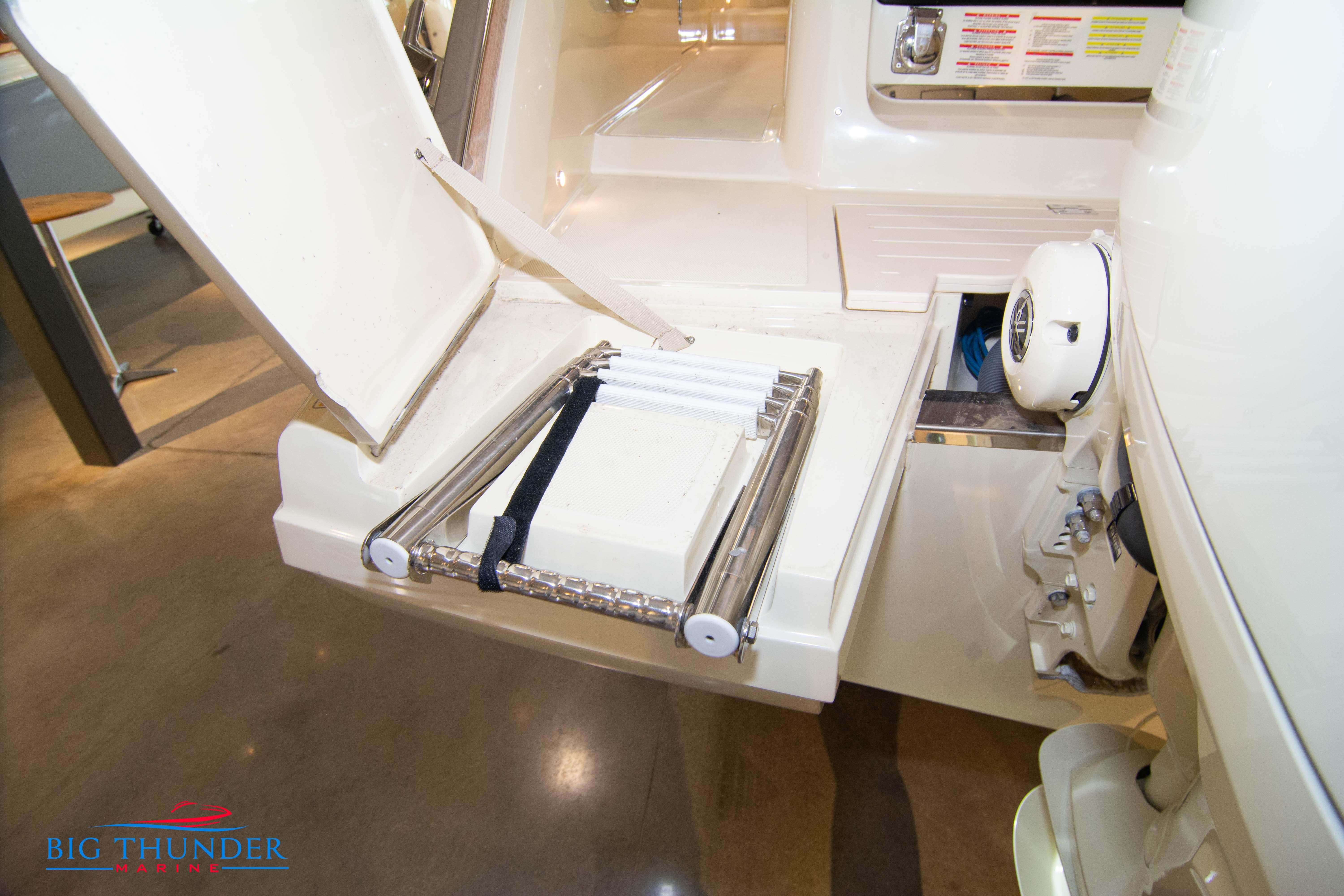 2024 Invictus GT320S boat with open storage compartment and folded ladder.