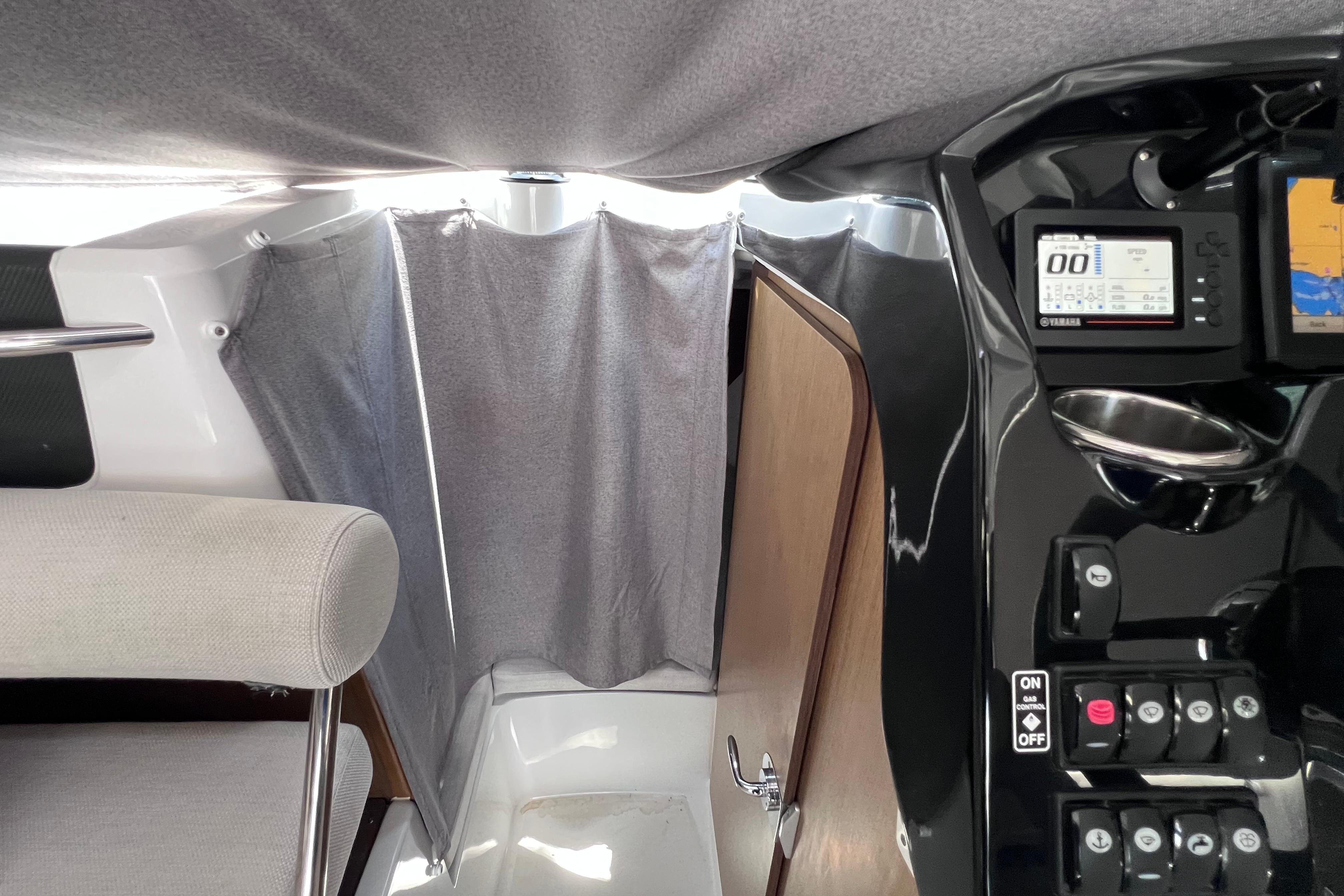 Interior of 2021 Jeanneau NC Weekender 795 Series 2 with control panel and curtain.