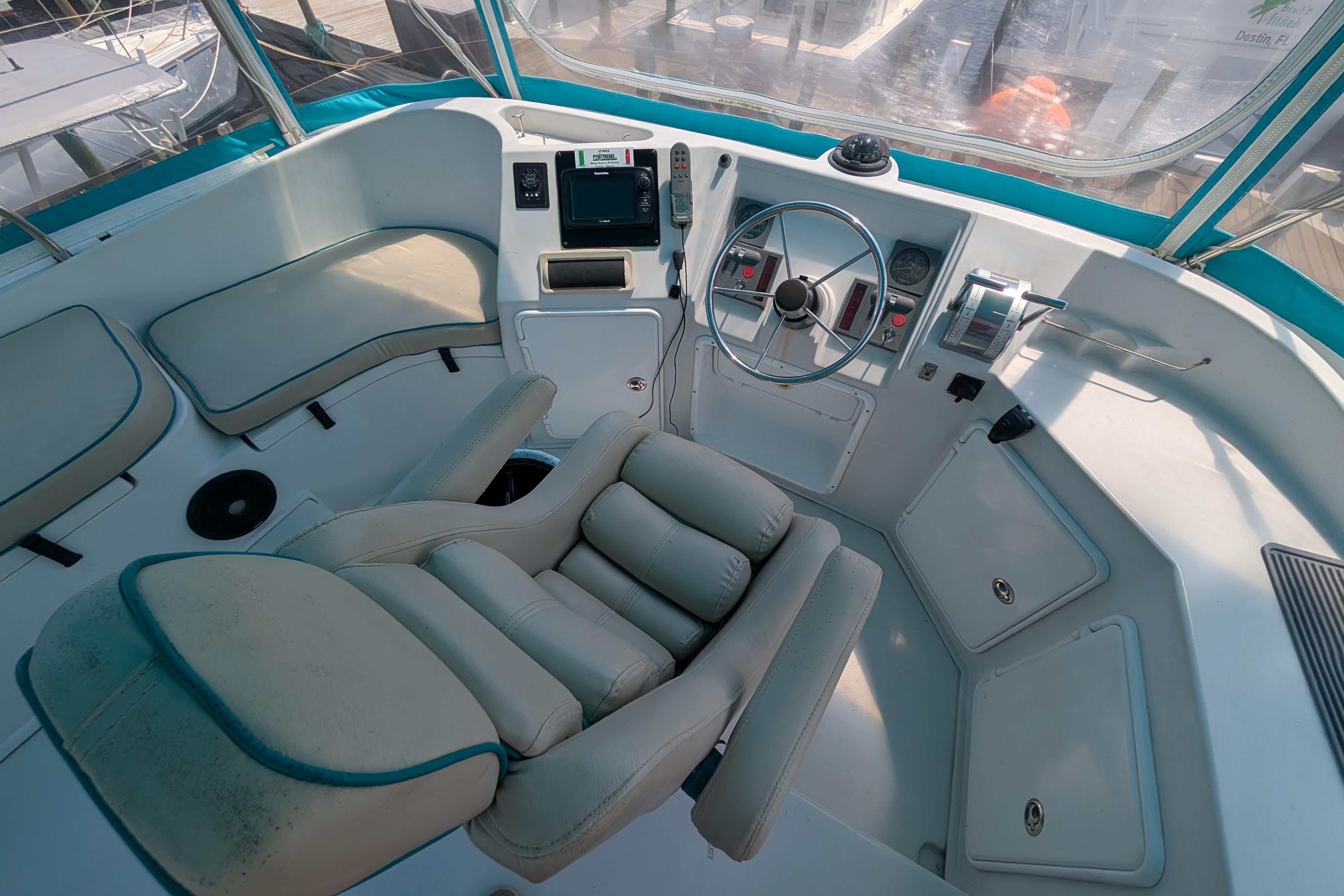 Helm of 2004 PDQ 34 Powercat with cushioned seating and navigation controls.