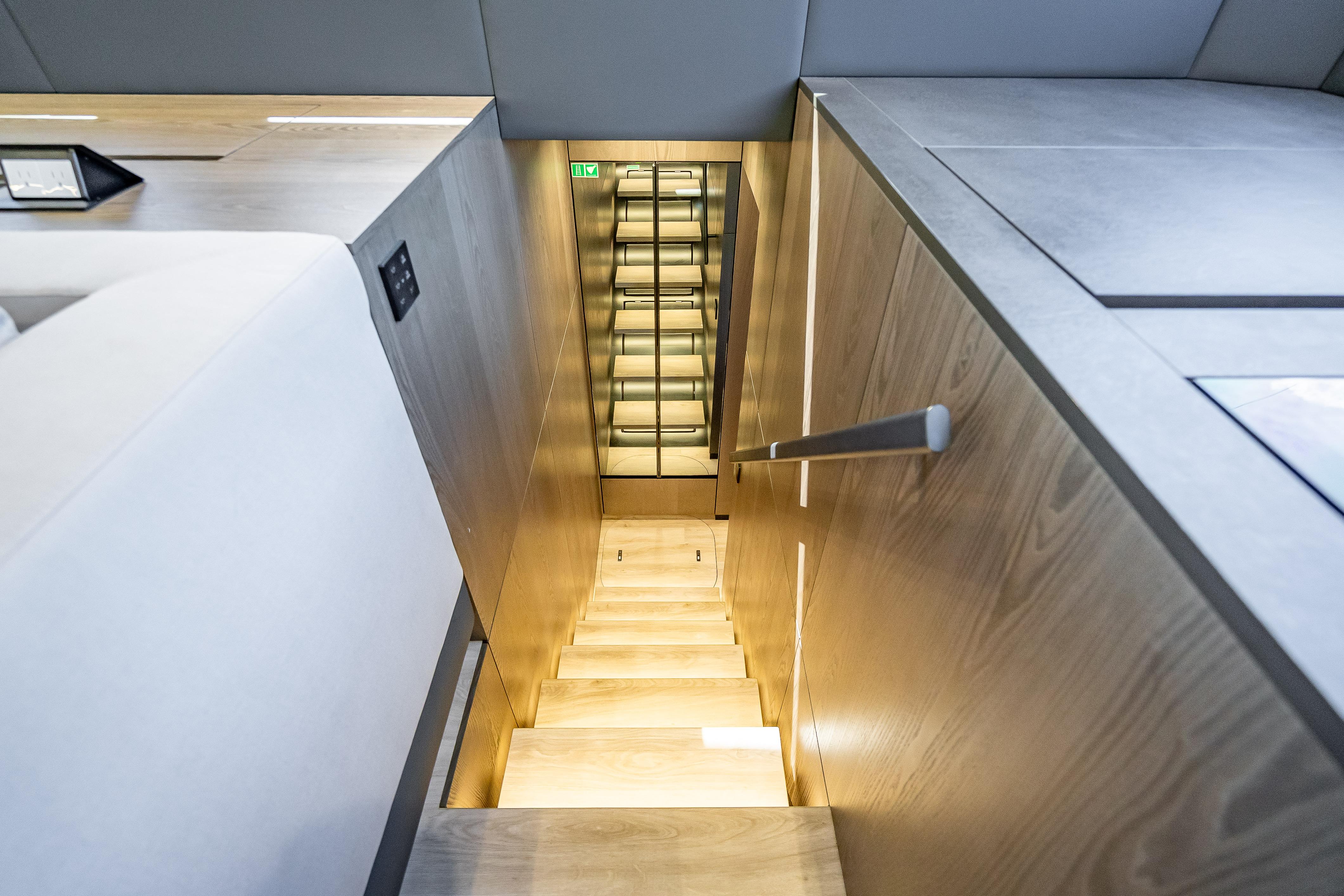 Modern interior staircase on 2026 Sunreef 60 Power yacht, featuring sleek wooden design.