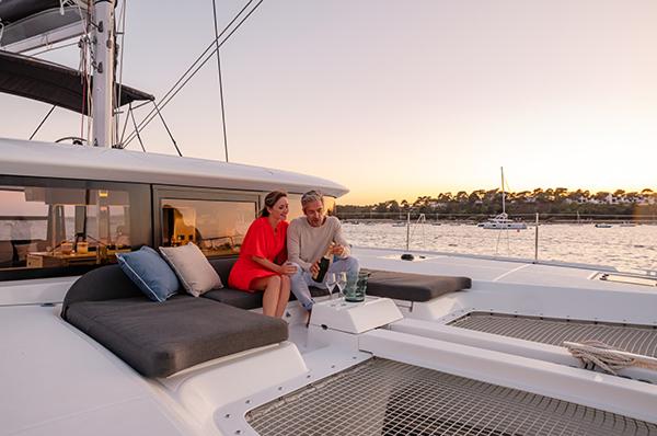 Couple relaxing on Lagoon 46 ICONIC yacht at sunset, 2025 model.