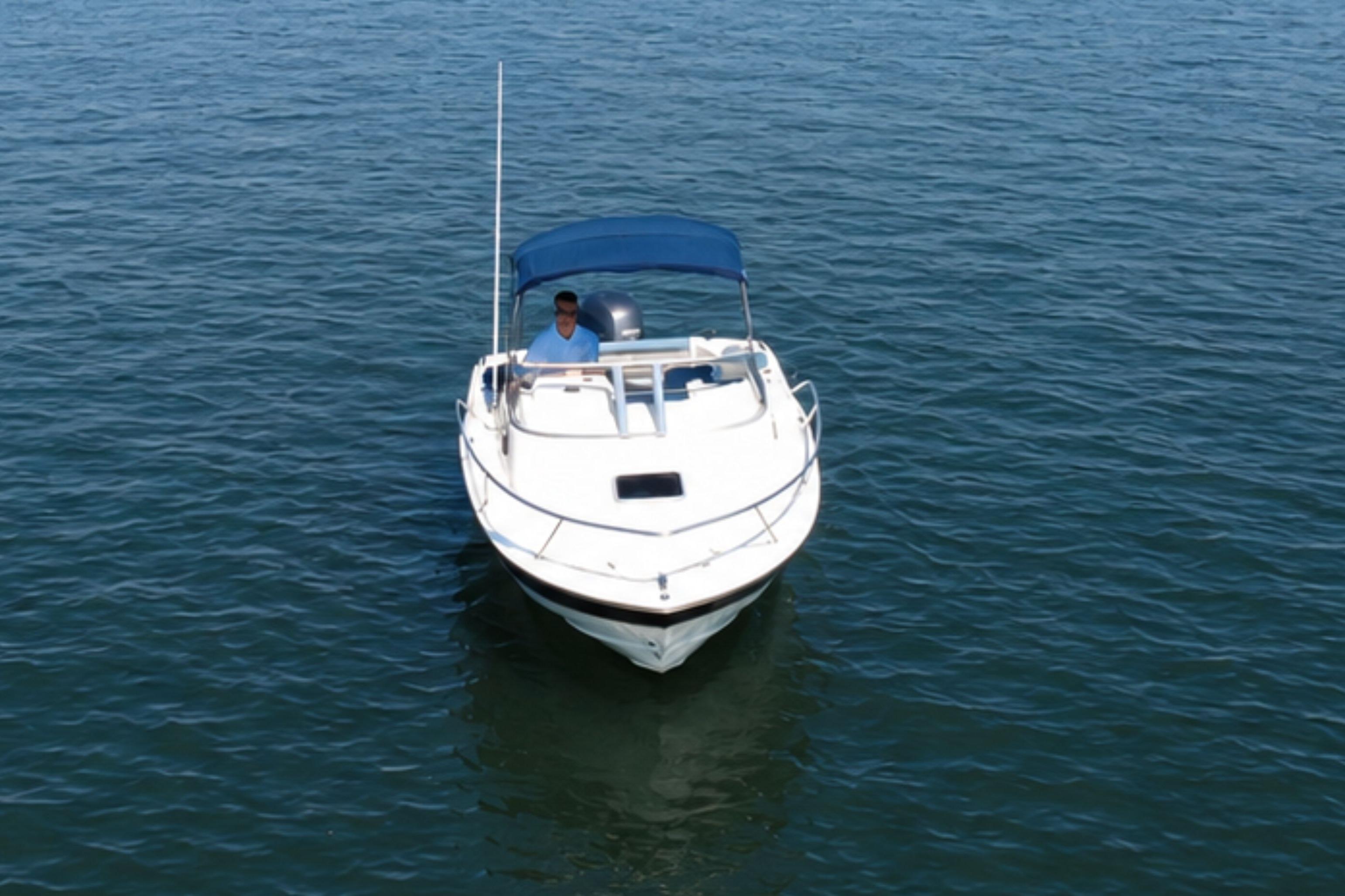 2008 Scout 222 Abaco boat with blue canopy on calm water.