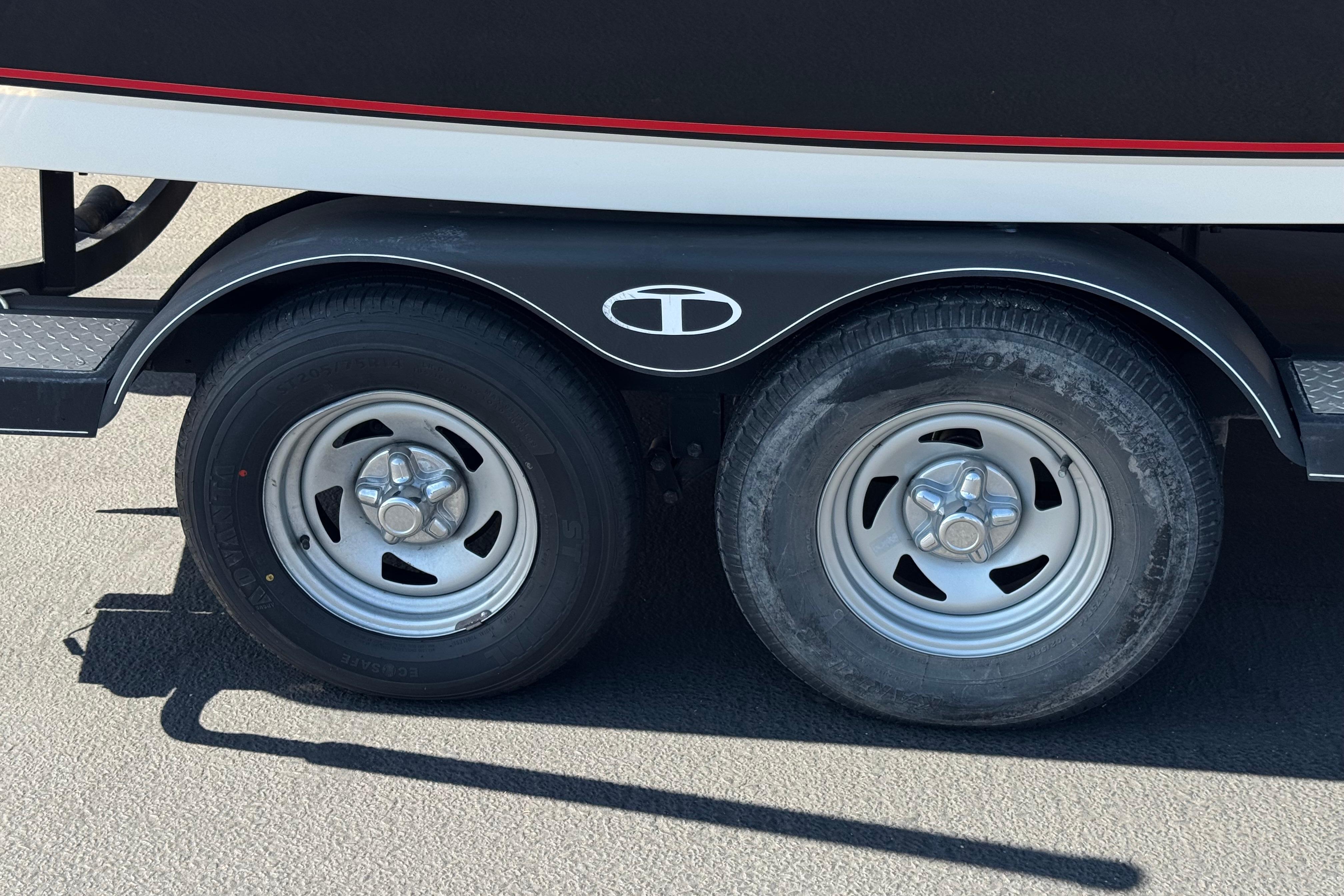 Trailer wheels of a 2019 Tahoe 2150 boat on pavement.
