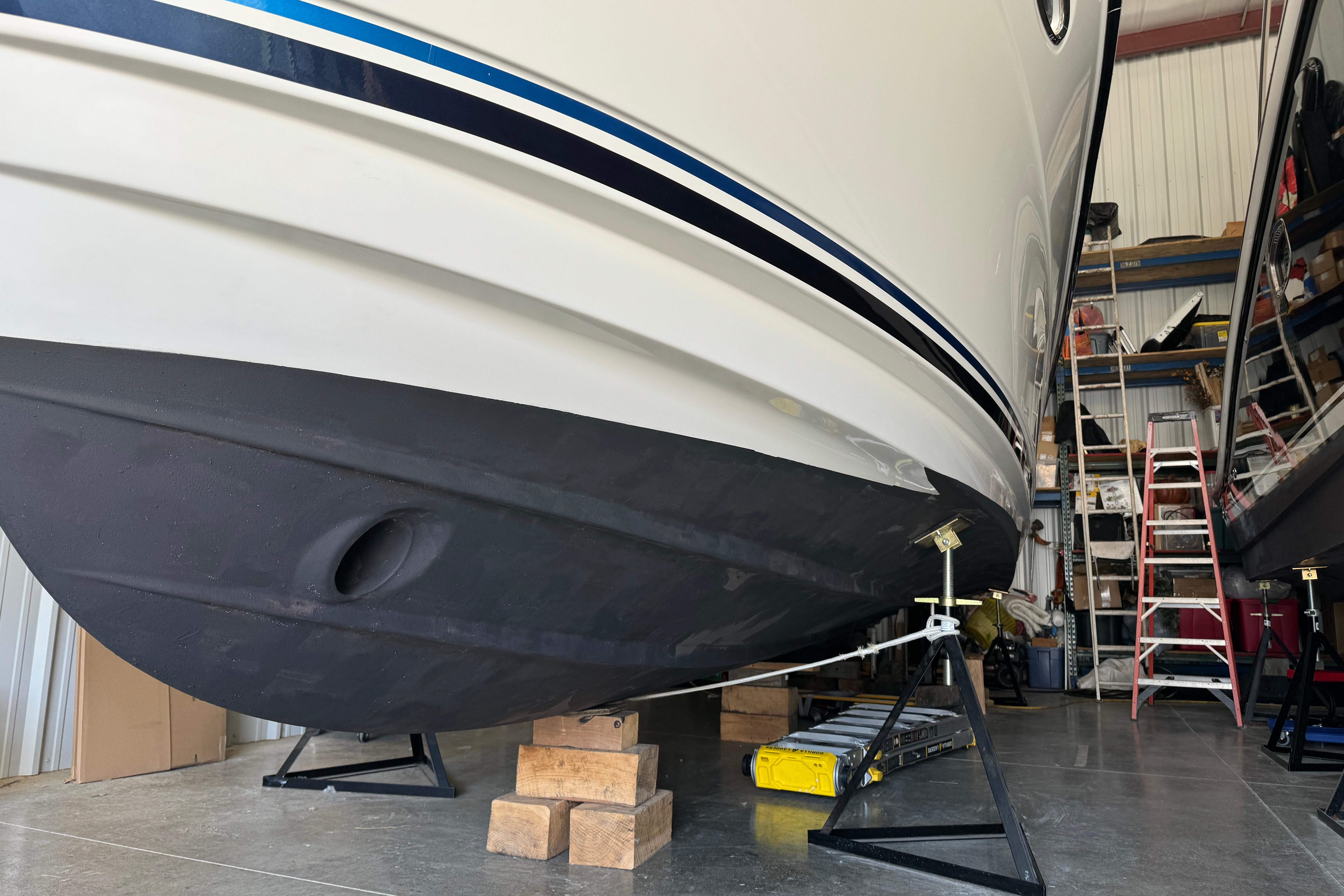 2017 Cutwater C-30 Sedan boat in storage, supported by stands, with visible hull and ladder.