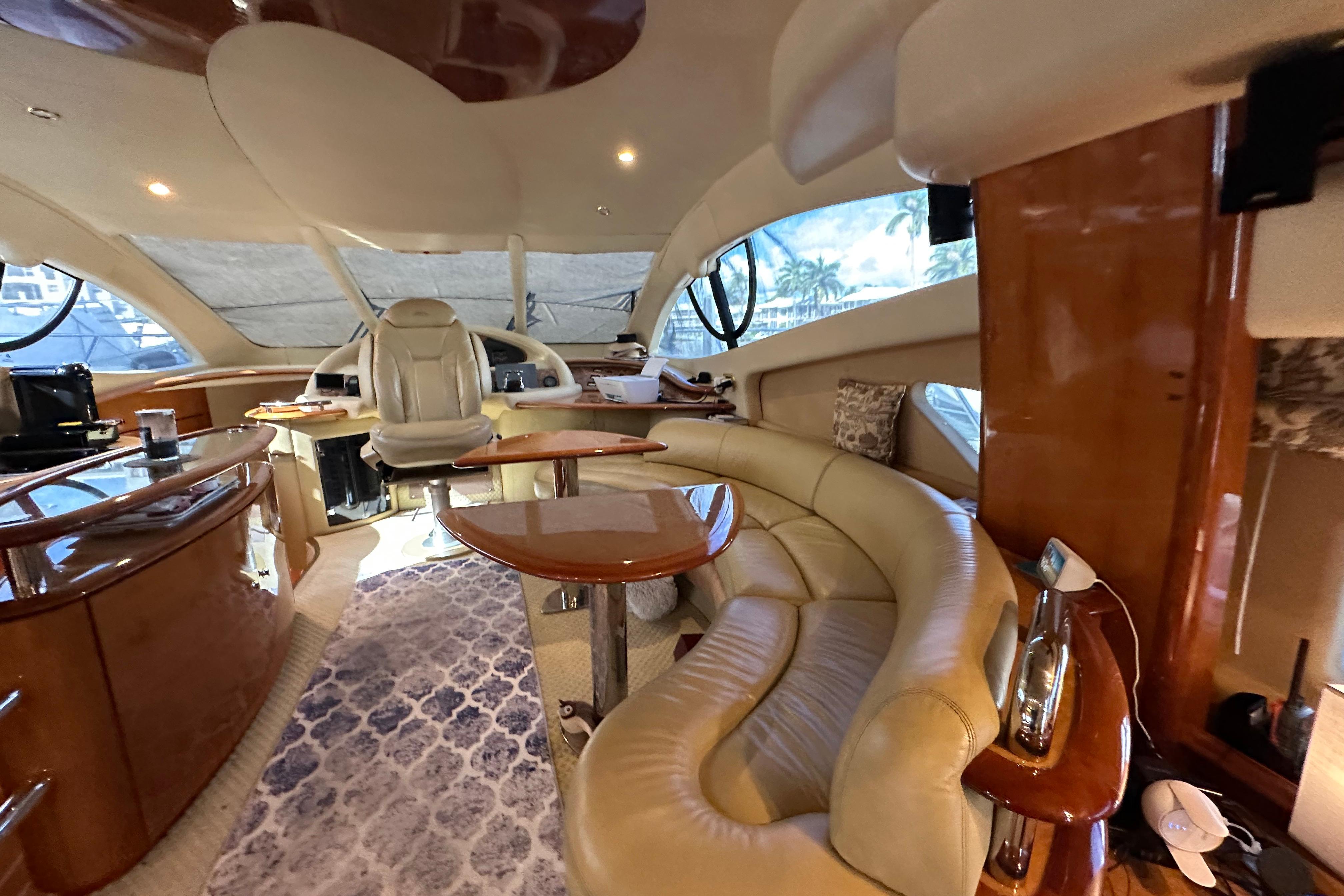 Luxurious interior of a 2004 Azimut 55E yacht with elegant seating and polished wood finishes.