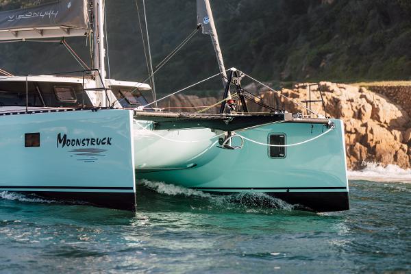 Vision 444 ES catamaran sailing near rocky coastline, 2025 model.