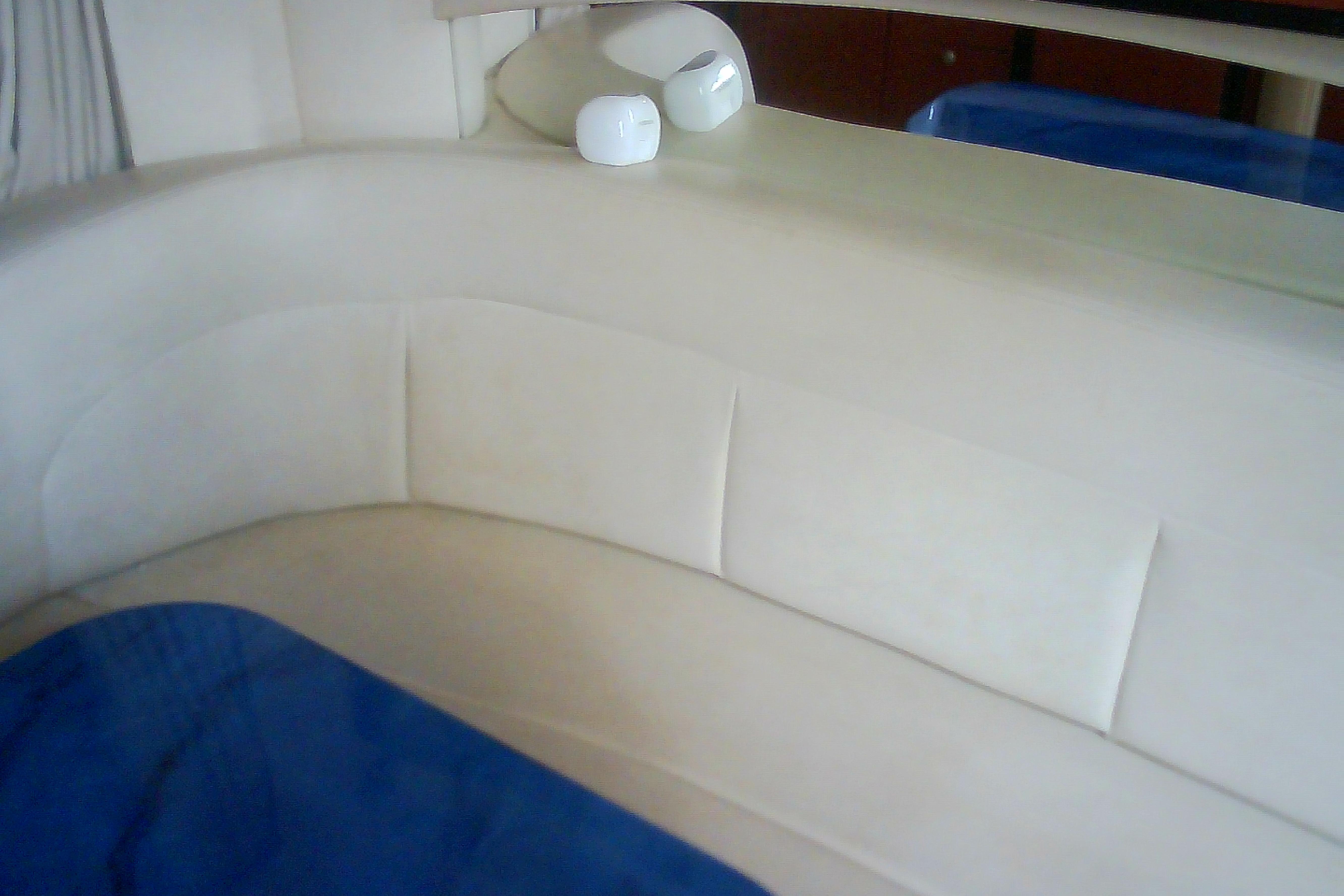 Interior seating of 2005 Sea Ray 300 Sundancer with beige upholstery and blue accents.