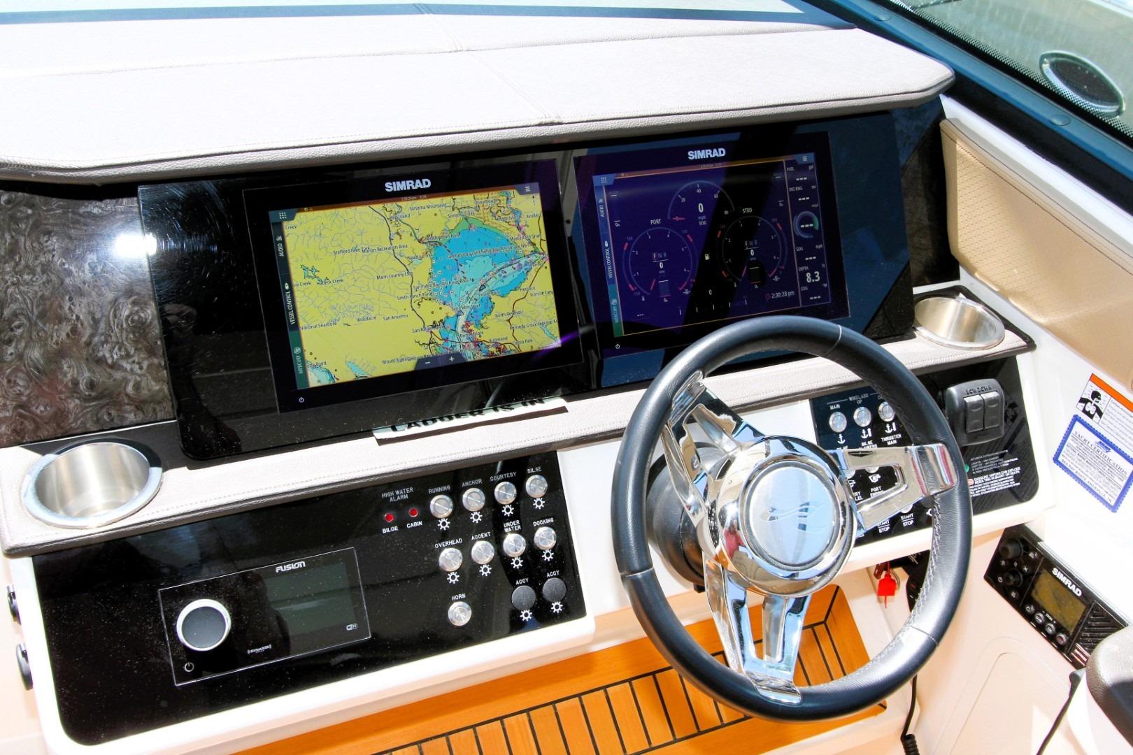 2021 Sea Ray Sundancer 320 Outboard helm with dual Simrad displays and modern controls.