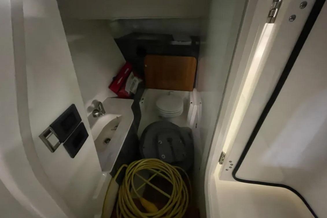 Interior of 2025 Boston Whaler 330 Vantage boat, featuring compact bathroom amenities.