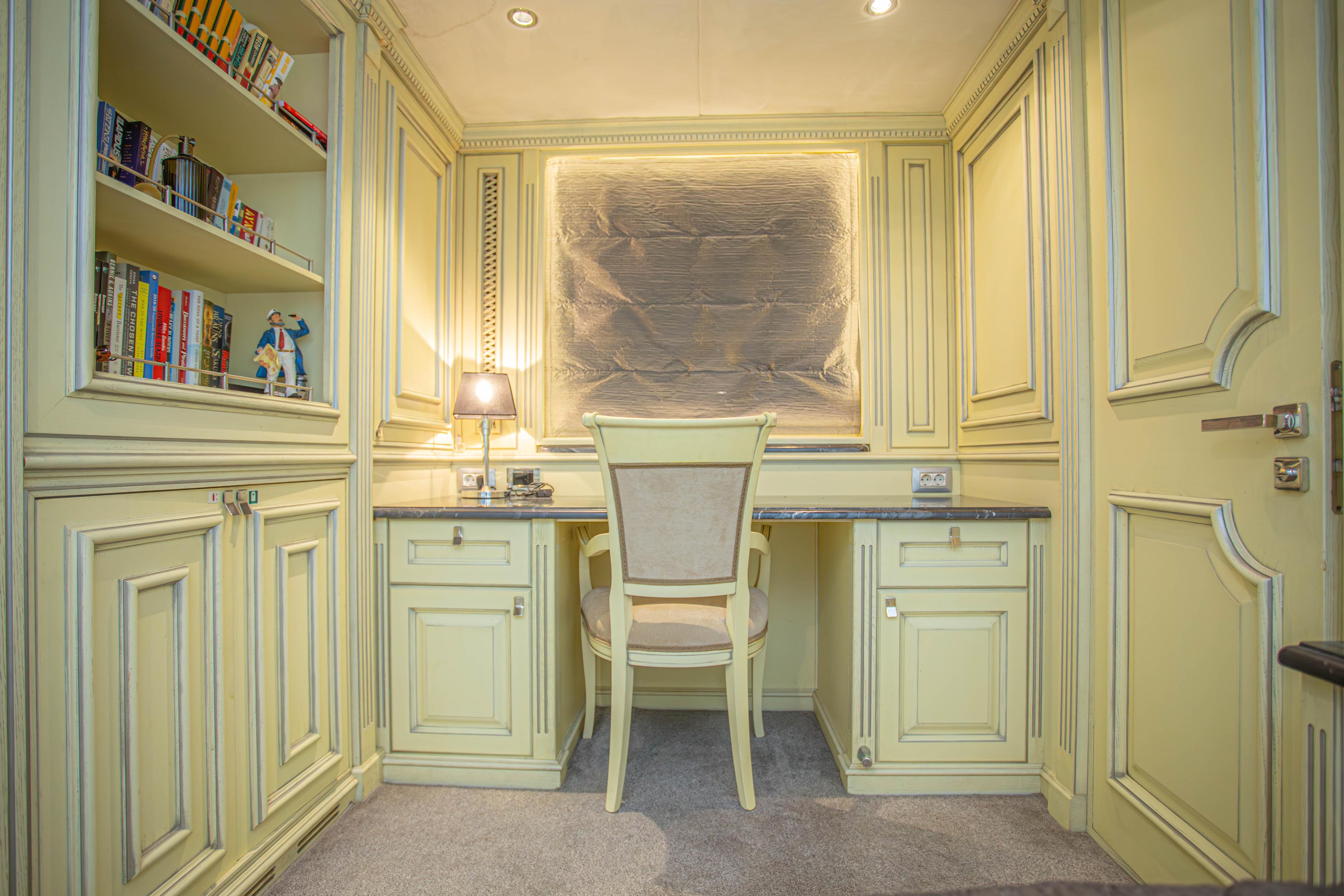 Luxurious study area on 2014 Fifth Ocean Yachts 24m Explorer Yacht, featuring elegant cabinetry and bookshelves.