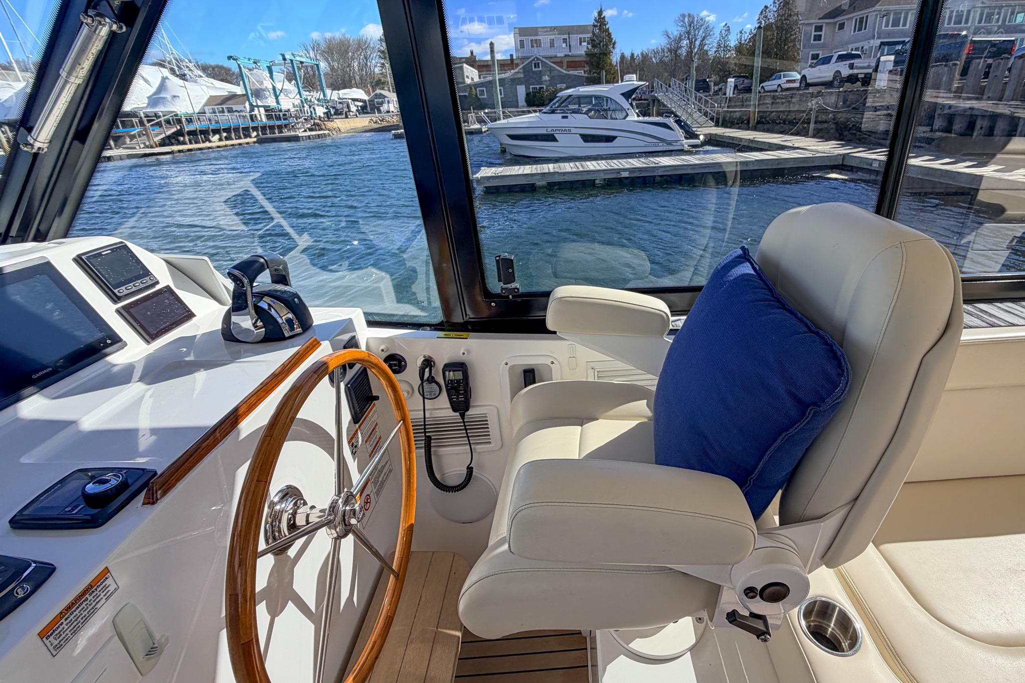 Interior of 2022 MJM 3 boat with helm, steering wheel, and plush seating.