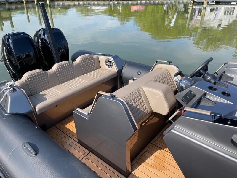 2022 Roughneck 1010 boat interior with seating and dual engines on calm water.