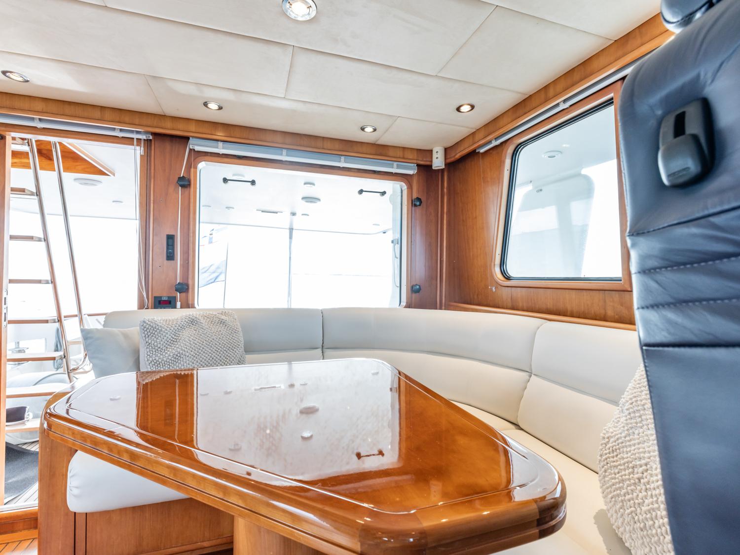 Interior of 1998 Moonen 68 Flybridge yacht with elegant wood and leather seating.