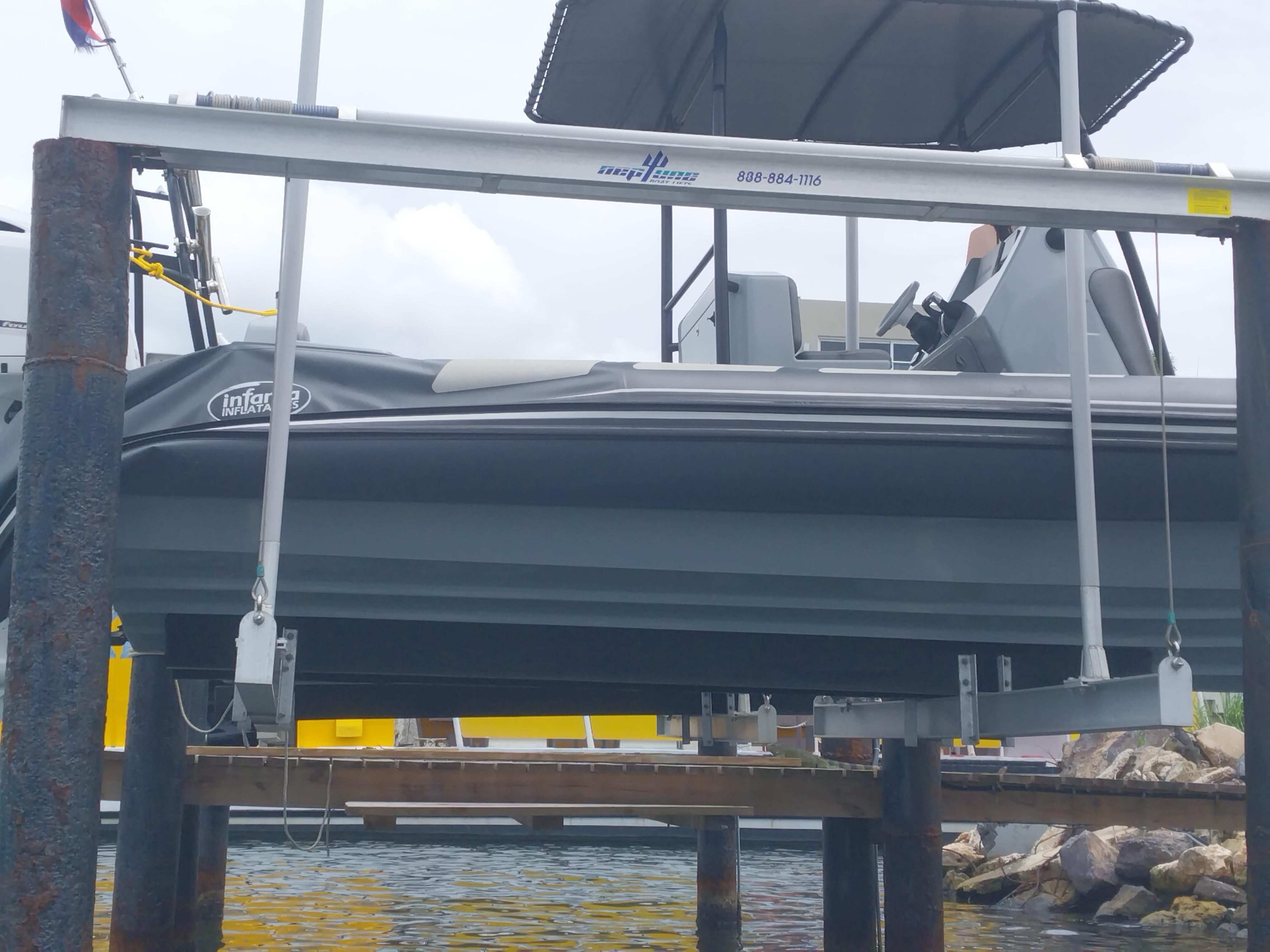 Infanta 8.5 boat from 2022 on a boat lift by the water.