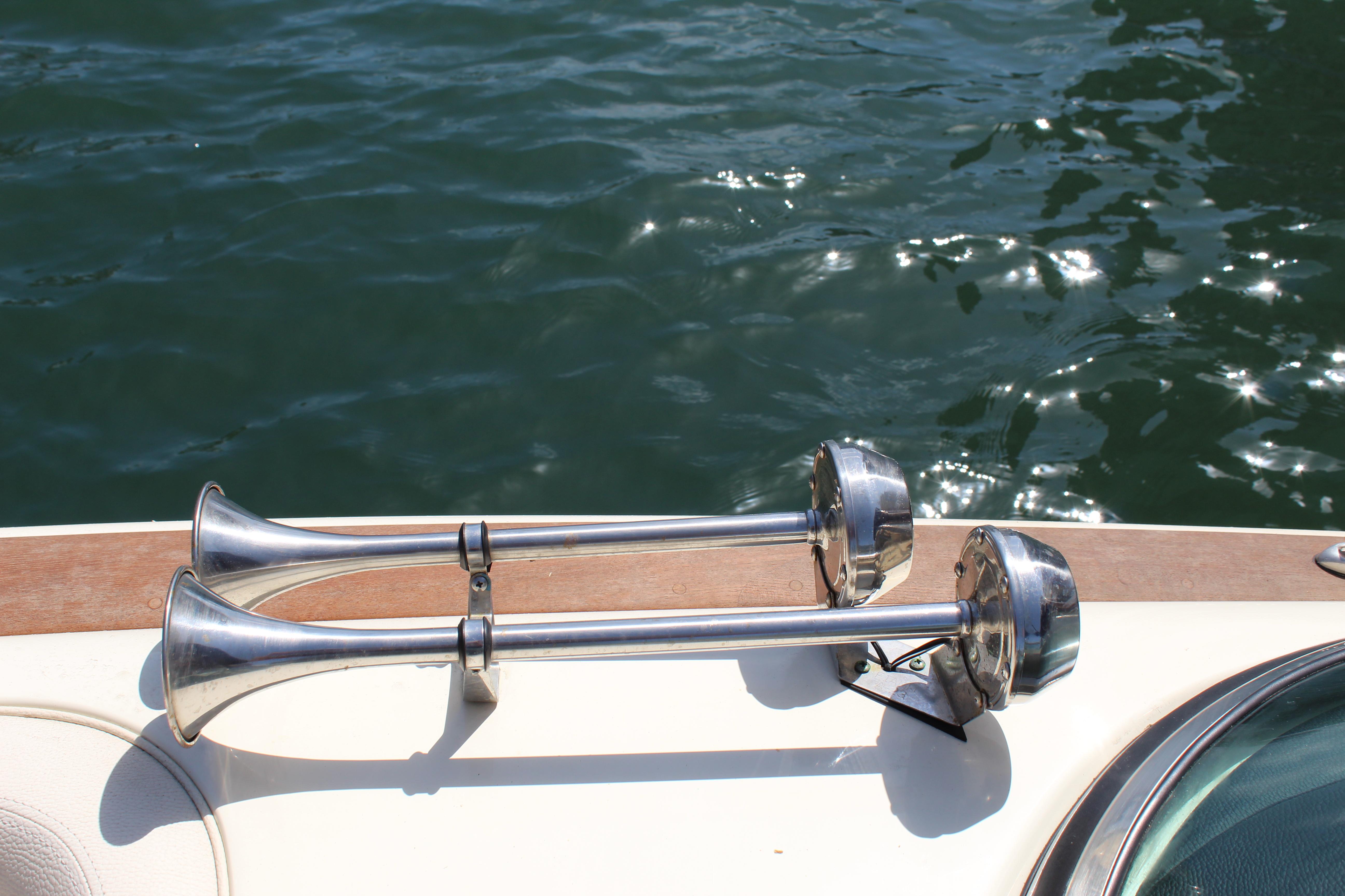 2022 Chris-Craft Launch 27 boat horns on deck, reflecting sunlight over water.