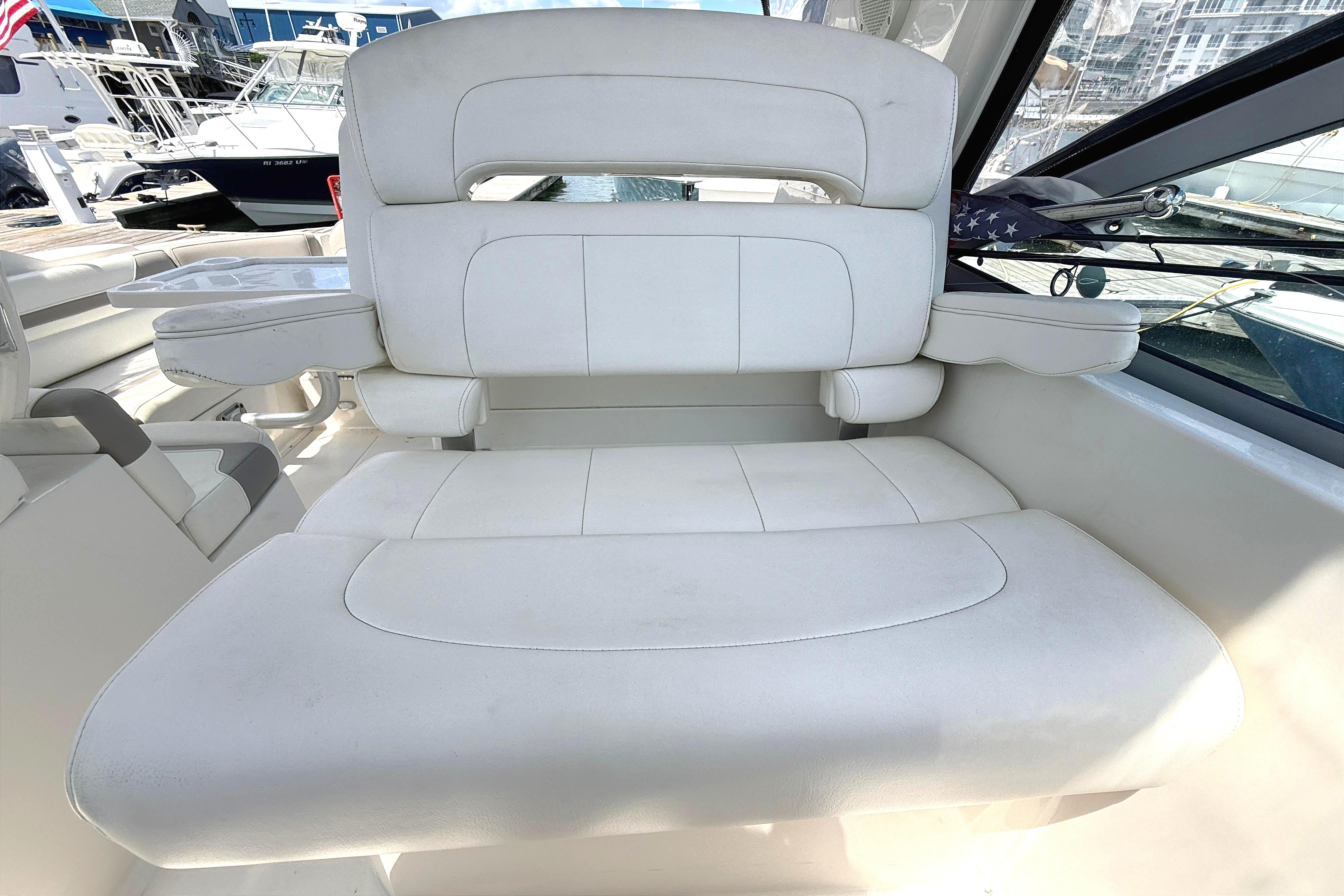 White leather seating on a 2011 Monterey 320 Sport Yacht, docked at a marina.