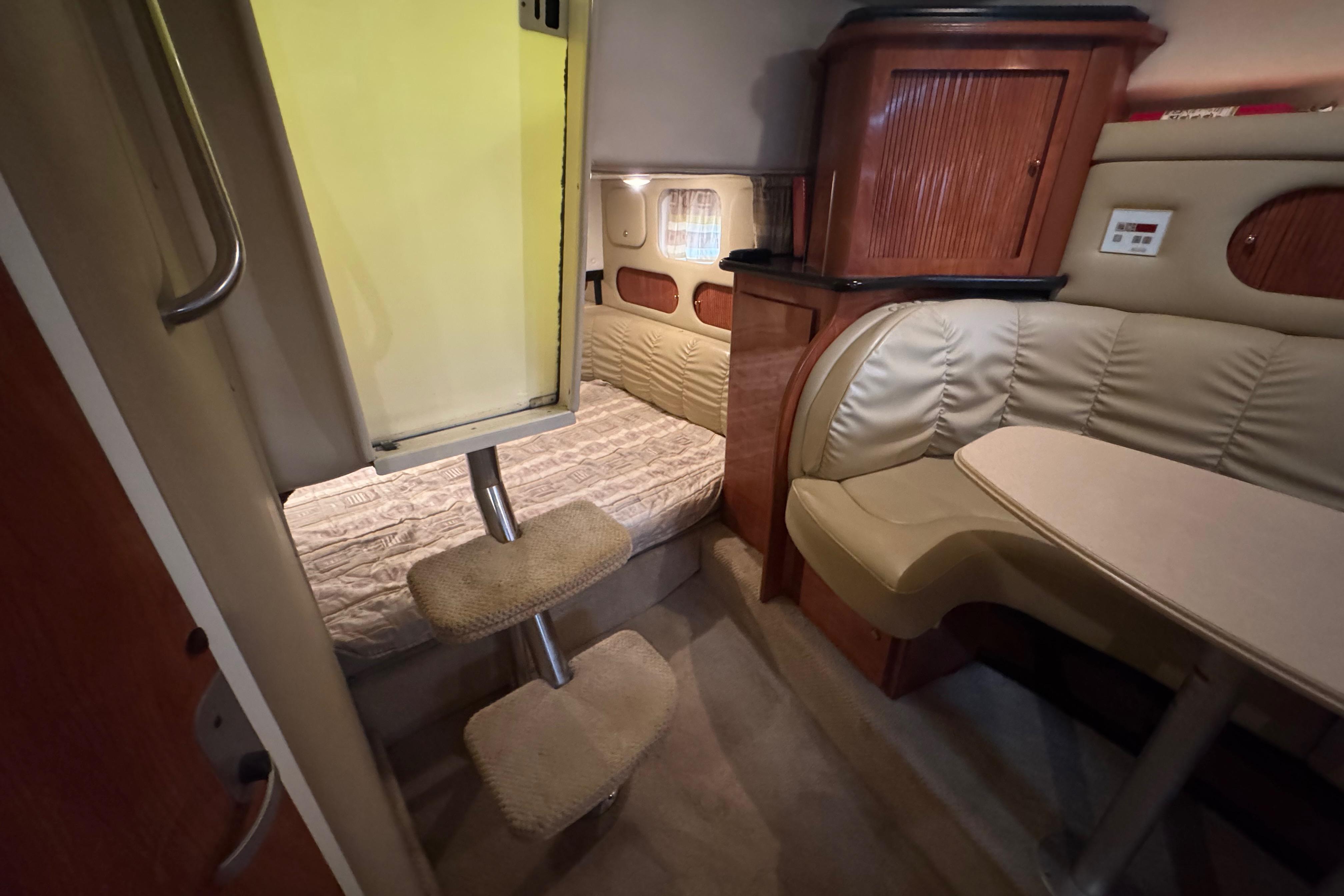 Interior of 2004 Rinker Fiesta Vee 312 boat with cozy seating and sleeping area.